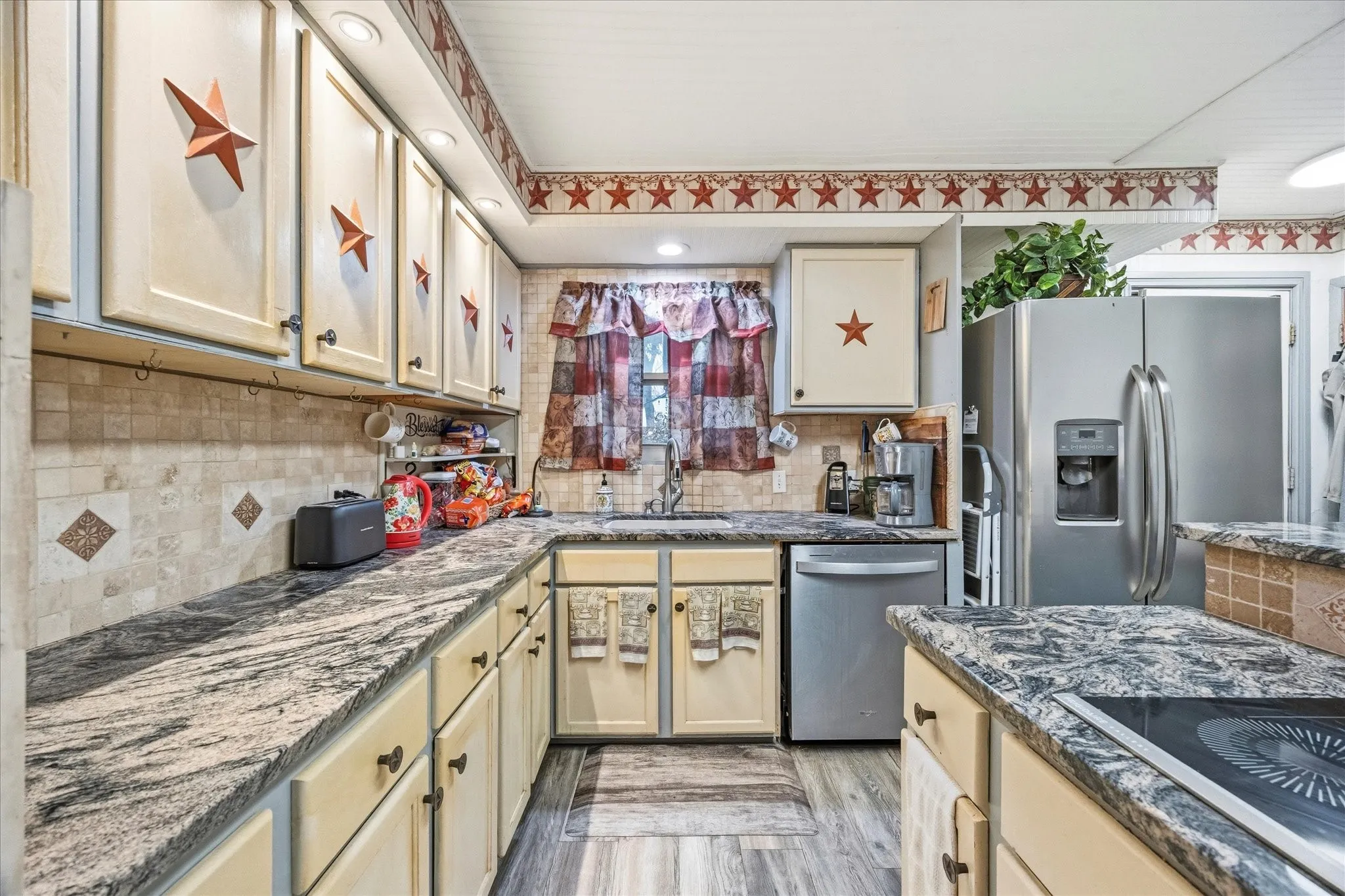 Kitchen includes granite countertops, an abundance of cabinetry and stainless steel appliances