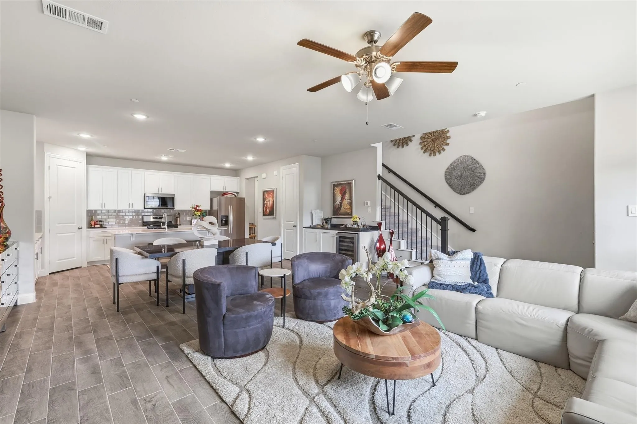Living Room with a Spacious and Airy Layout, Generous Wall Width, and Large Rectangular Walls ideal for Mounted Installations or Decorative Treatments. A Centered Ceiling Fan, Large Windows, and Power Blinds provide Functional Airflow, Abundant Natural Light, and Privacy, creating a Modern Architectural Feel with High Ceilings, Open Floor Space, and a Neutral Color Palette that supports Flexible Layout and Contemporary Design Styling.