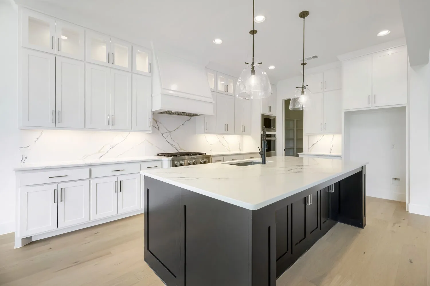 Central kitchen island with a white countertop and dark cabinetry