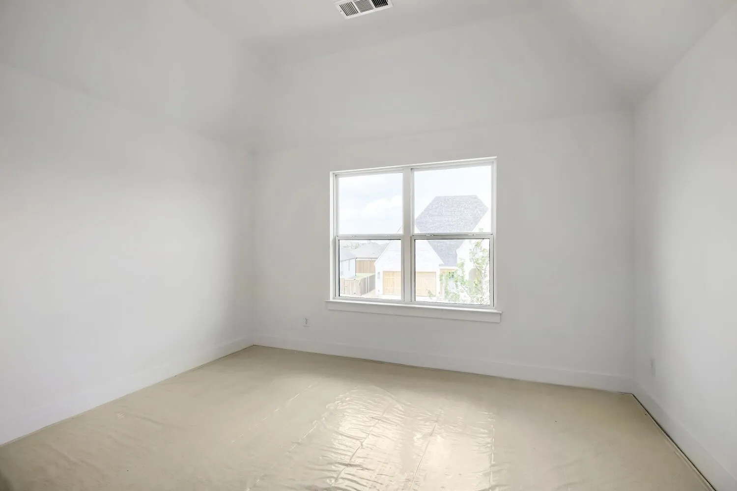 Vaulted ceiling room featuring a large window with white trim, baseboards, and a ceiling vent