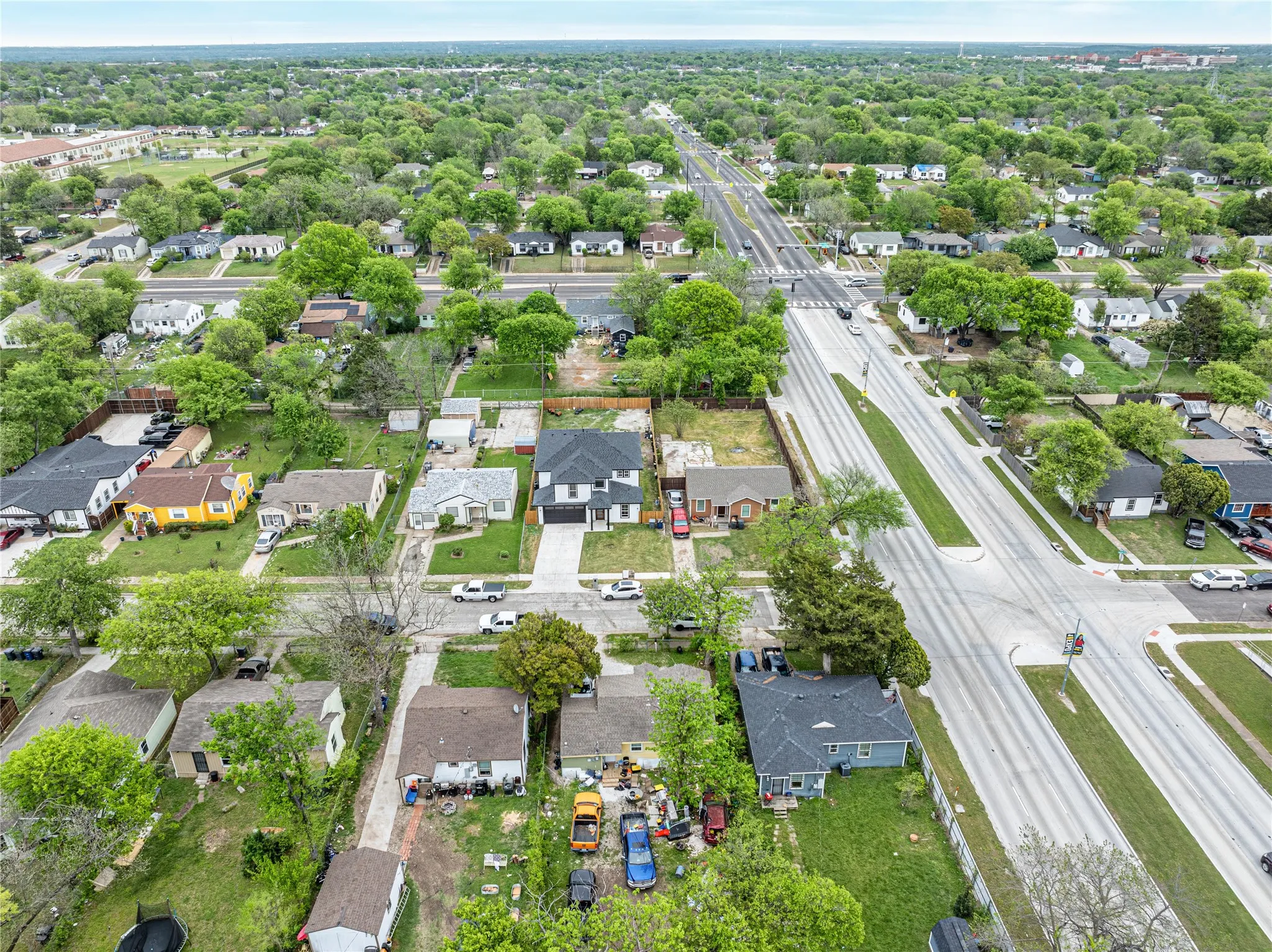Aerial view of property and surrounding area featuring nearby suburban area