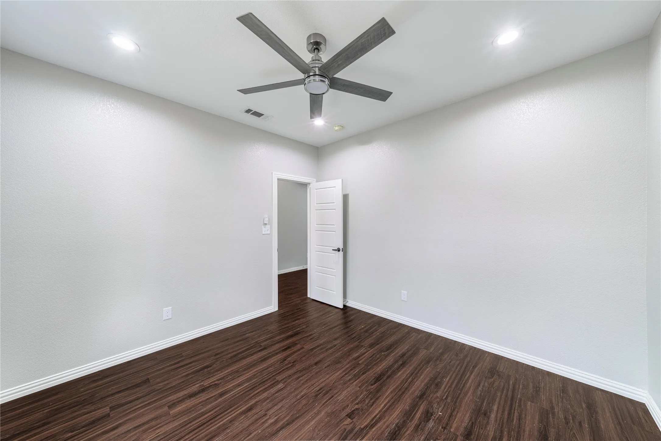 Unfurnished room with ceiling fan, dark wood-style flooring, and recessed lighting