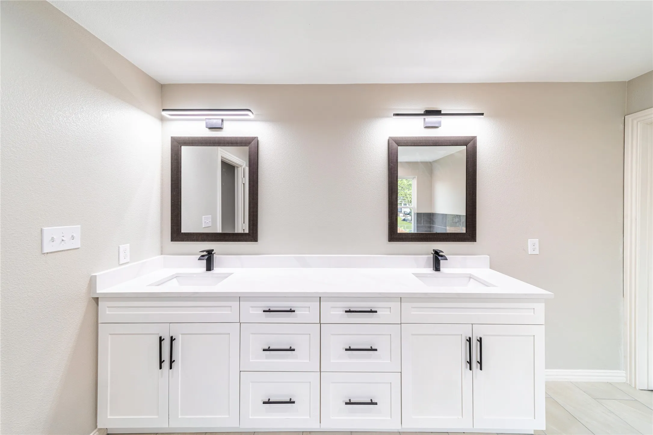 Full bath featuring double vanity and baseboards