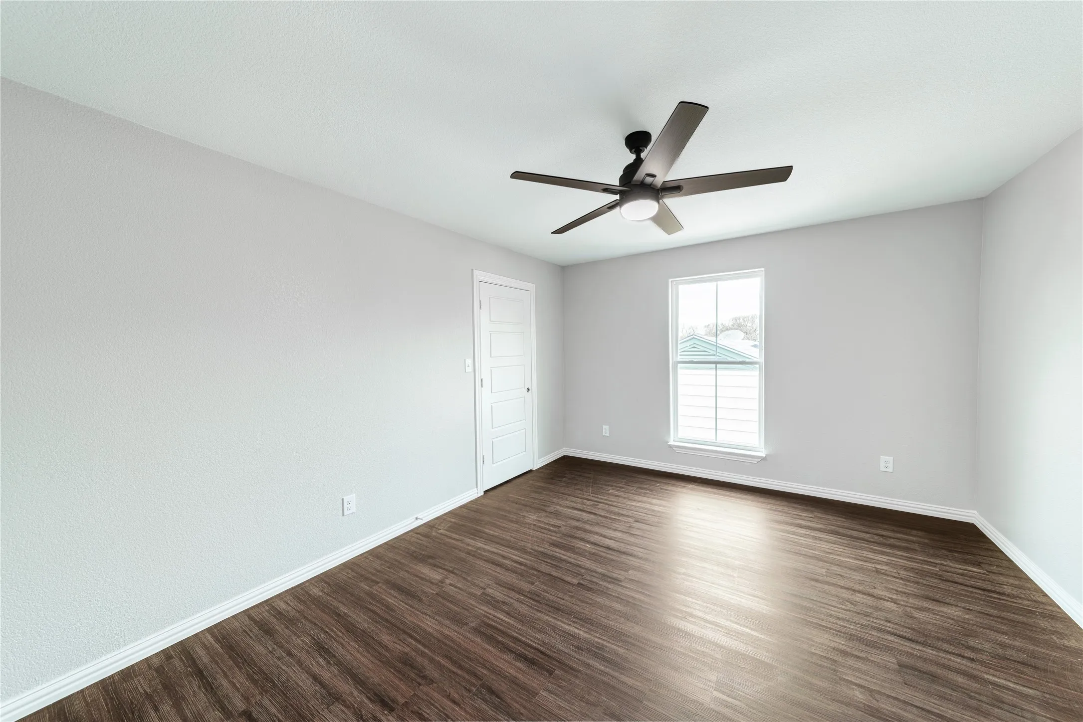 Spare room featuring dark wood-type flooring and a ceiling fan