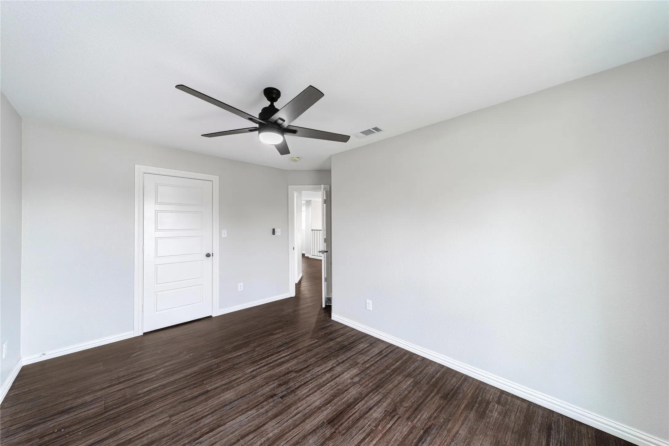 Unfurnished bedroom with dark wood finished floors, ceiling fan, and a closet