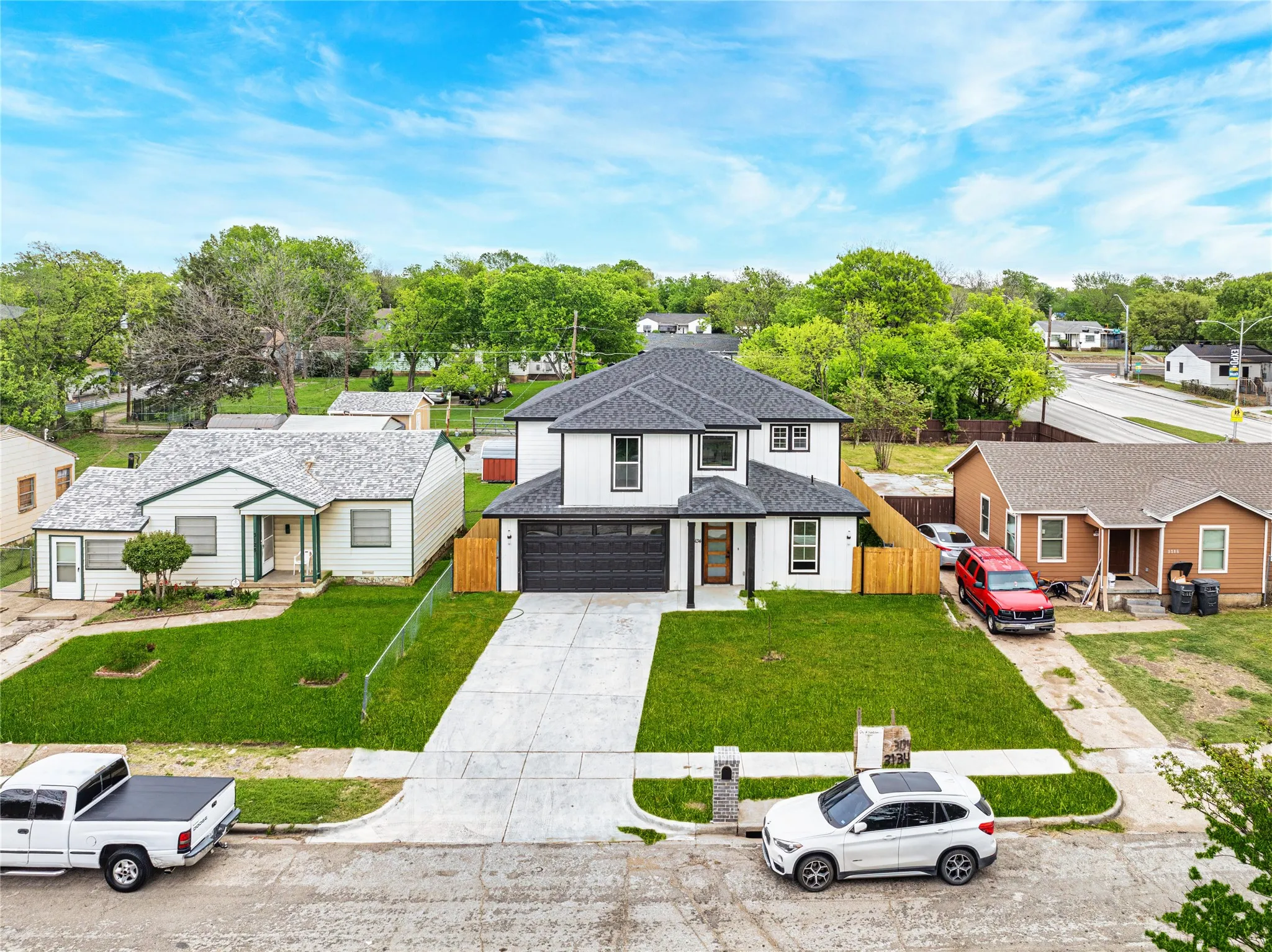 View of front of property with a residential view, concrete driveway, roof, and an attached garage