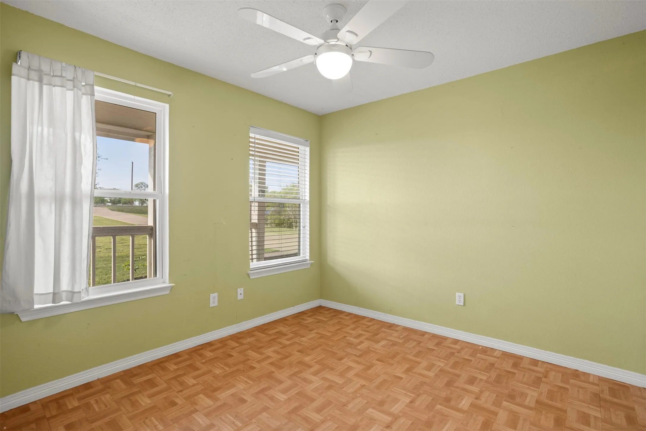 Unfurnished room featuring parquet floors, a ceiling fan, and a textured ceiling