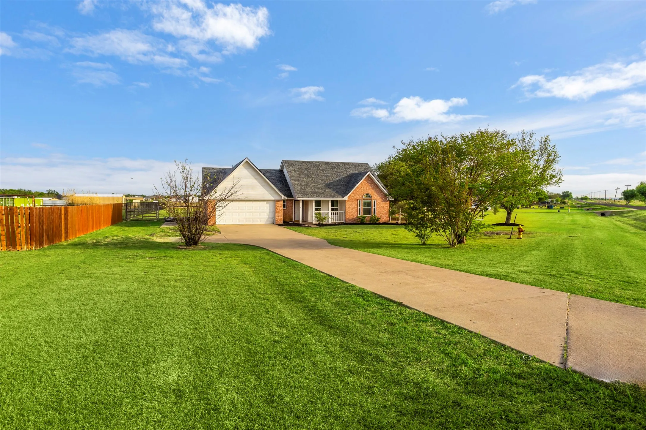 View of front of property with driveway, an attached garage, and brick siding
