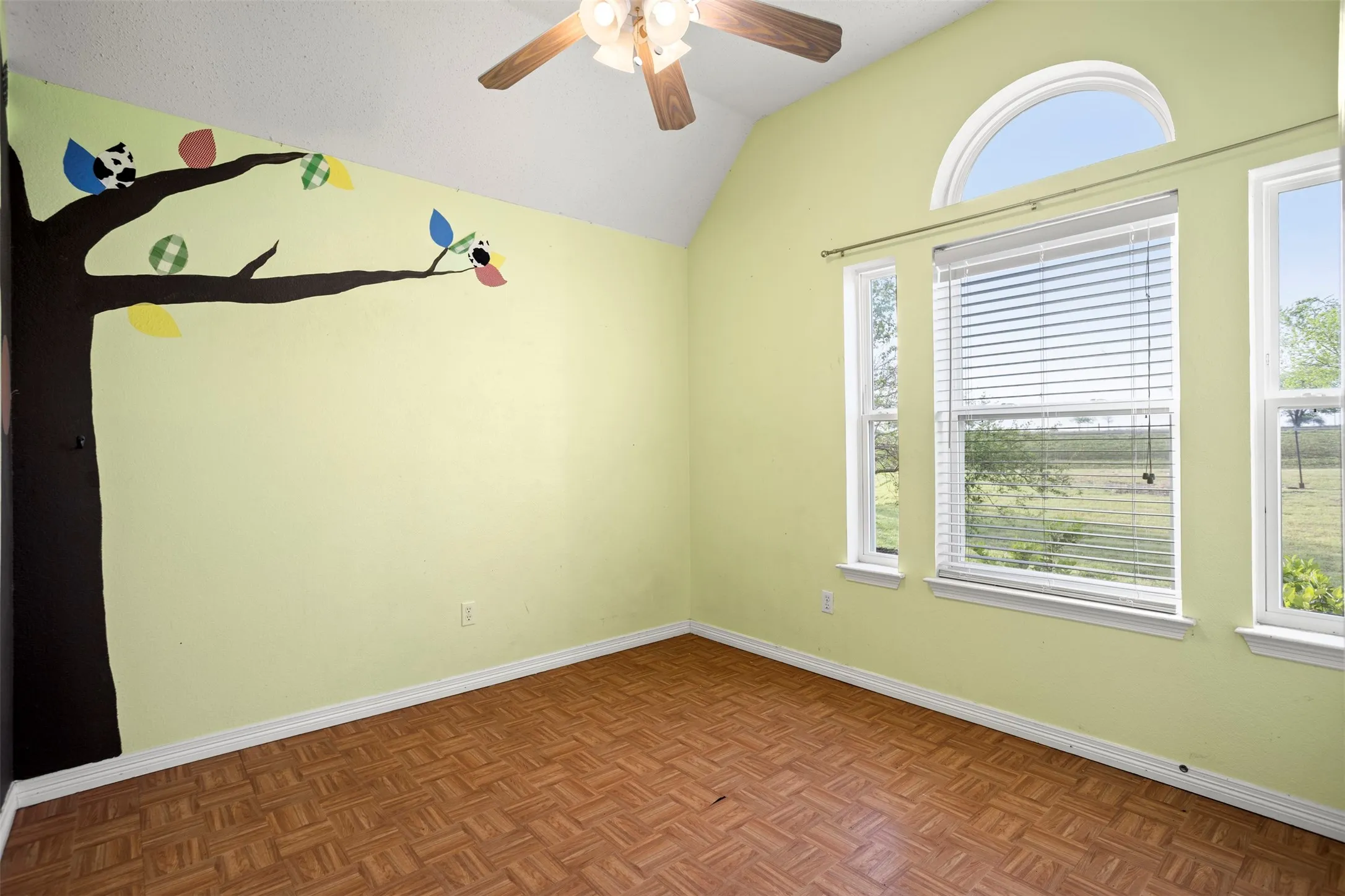 Unfurnished room with lofted ceiling, a ceiling fan, and parquet flooring