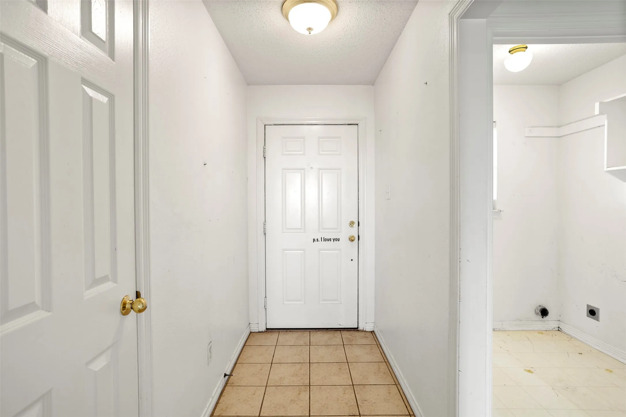 Entryway with a textured ceiling and tile patterned flooring