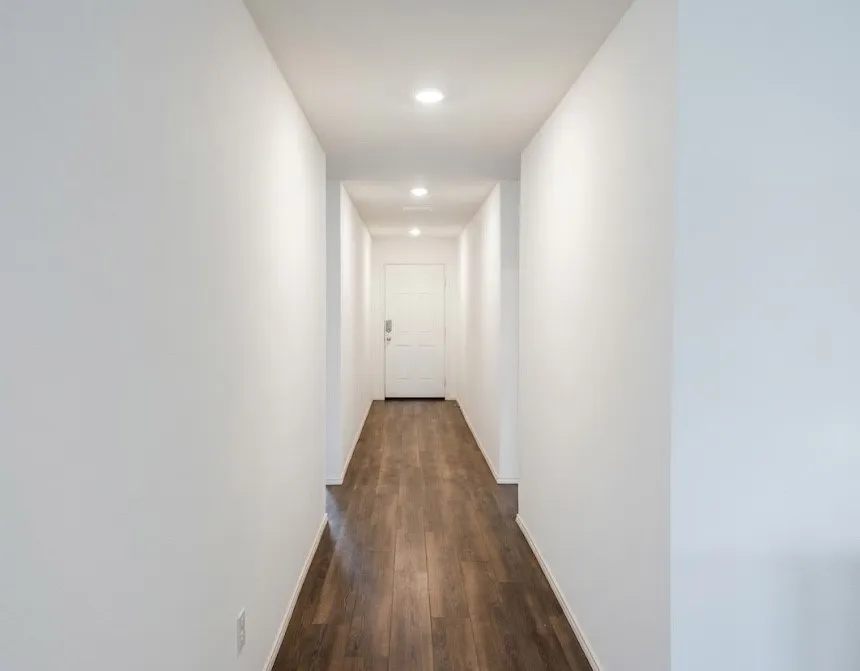Hallway with dark wood-style flooring and recessed lighting