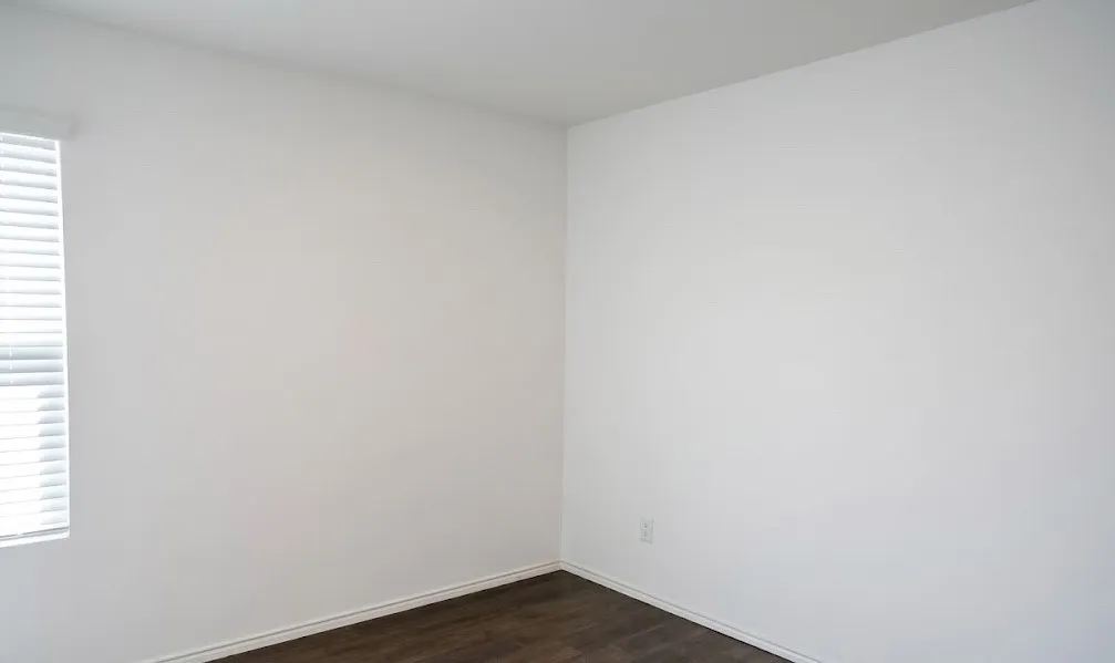 Unfurnished room with dark wood-style flooring and baseboards