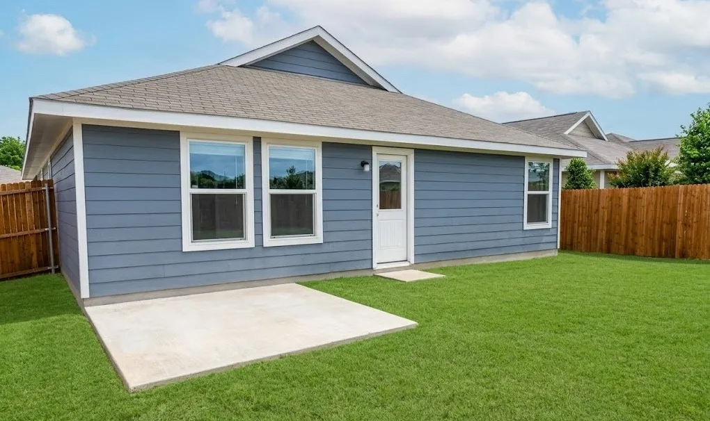Rear view of house featuring a fenced backyard, roof with shingles, and a patio
