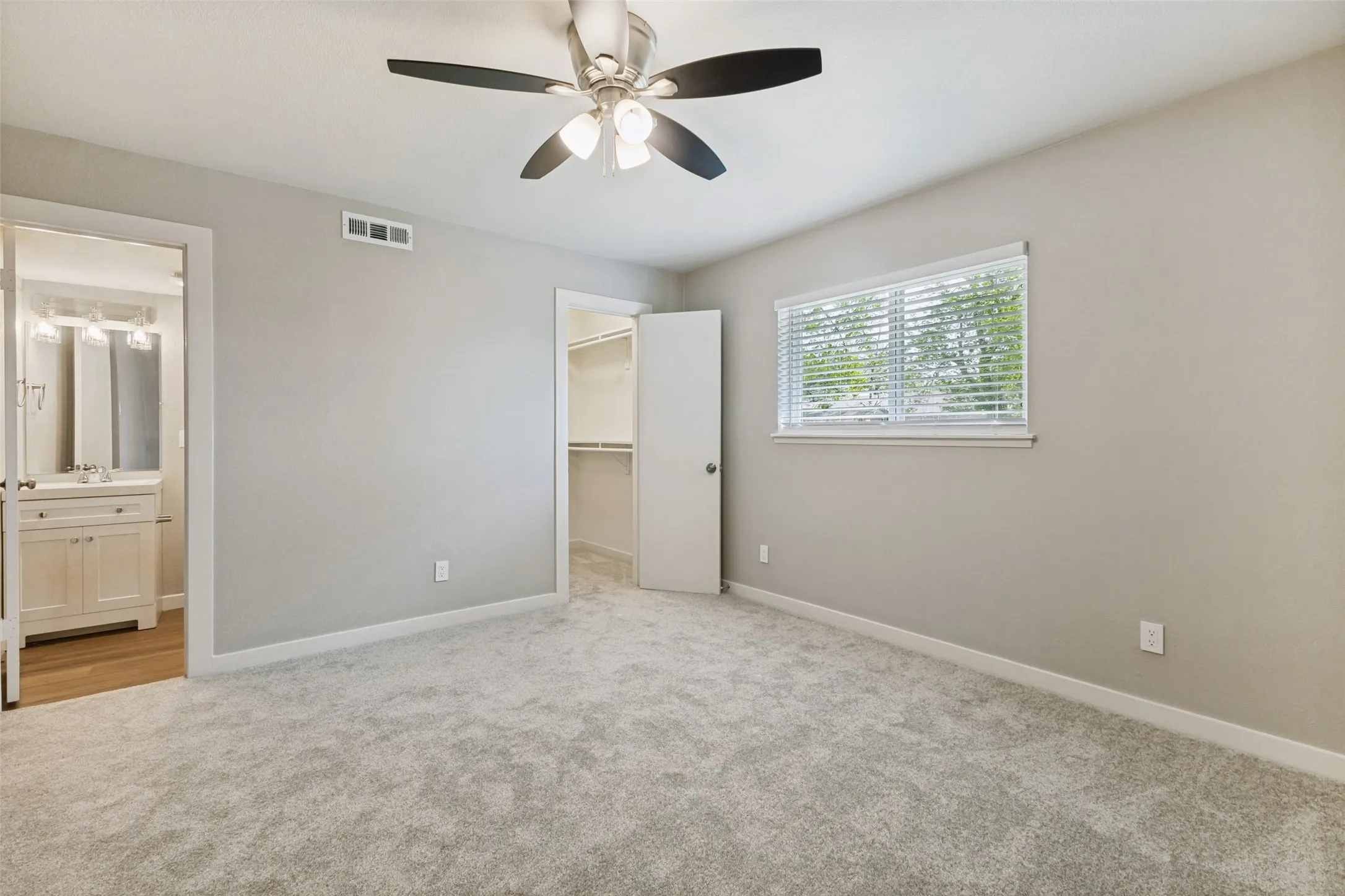 Serene color palette, lighted ceiling fan, and a spacious ensuite primary bath.