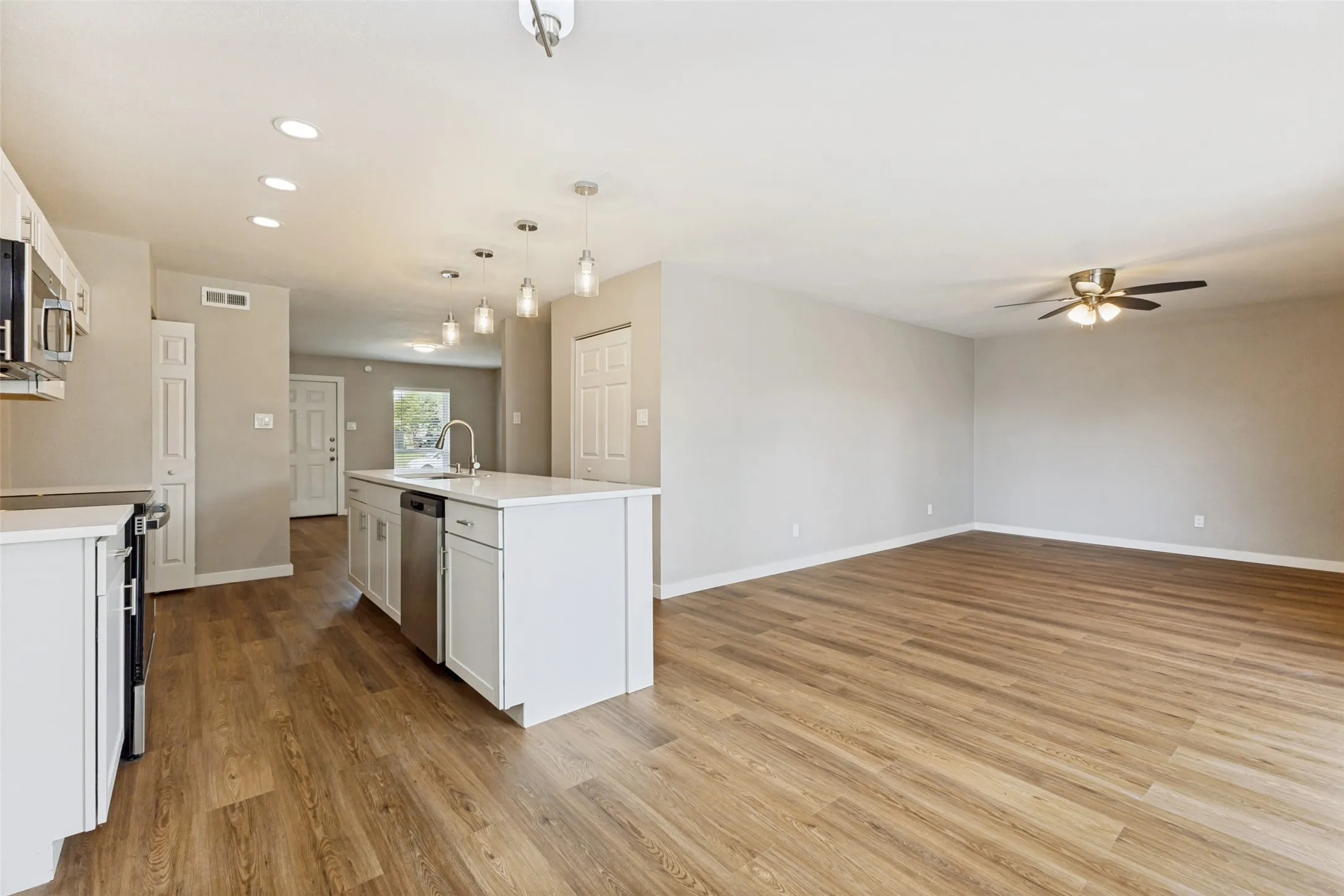 The entire area is wonderfully bright, thanks to gorgeous pendant lights and recessed can lighting that provide both style and functionality.