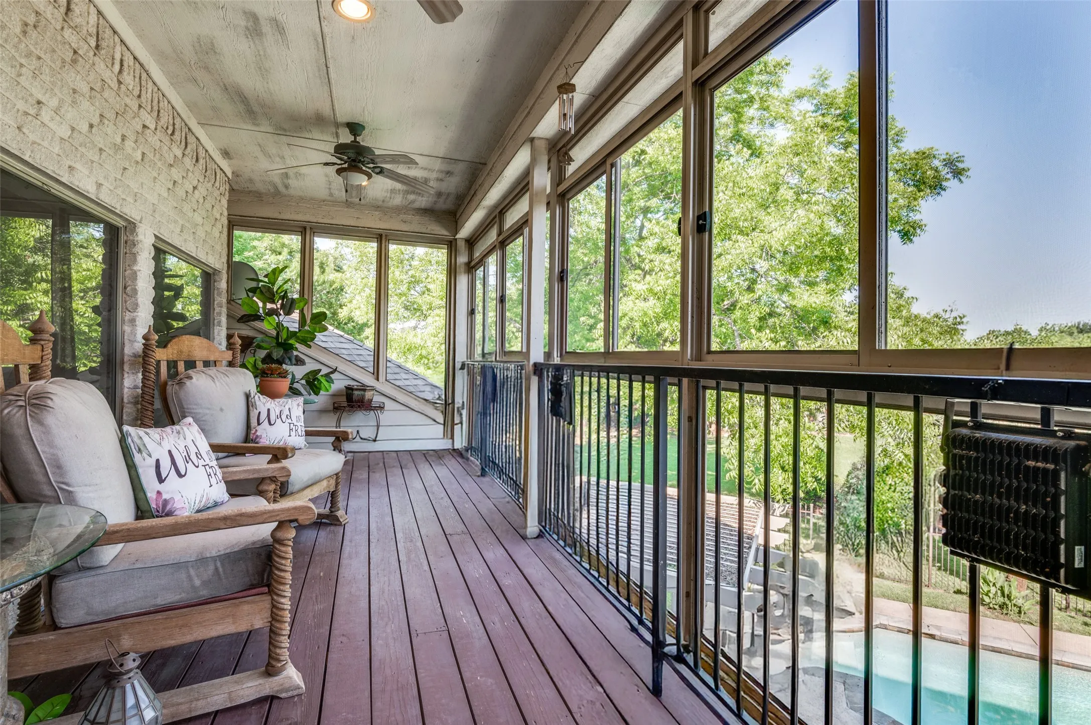upper screened in patio overlooking pool and backyard with view of pond