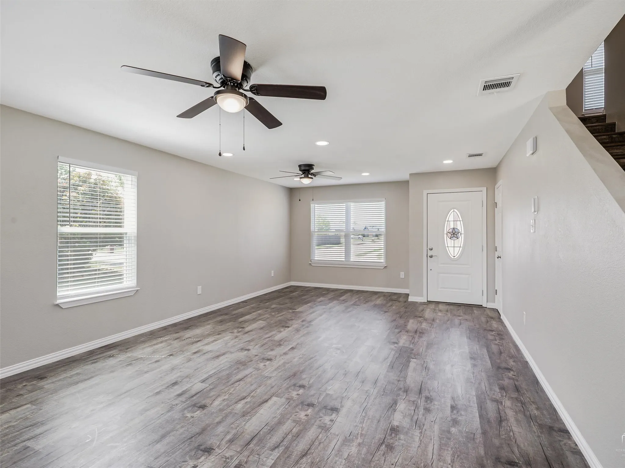 Open-concept living space featuring wood-finish flooring, recessed lighting, and multiple ceiling fans