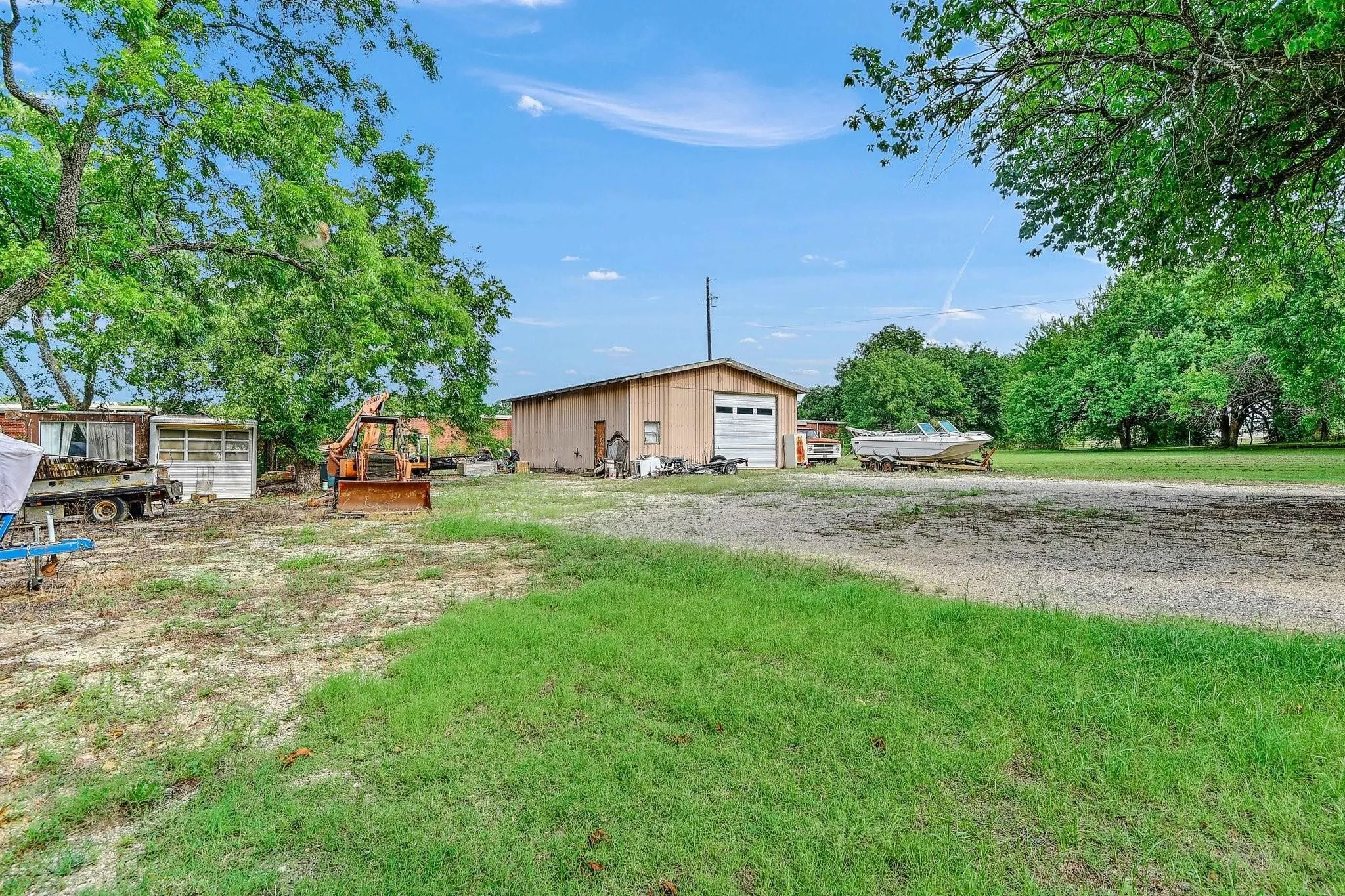 View of yard with an outbuilding, driveway, and a garage