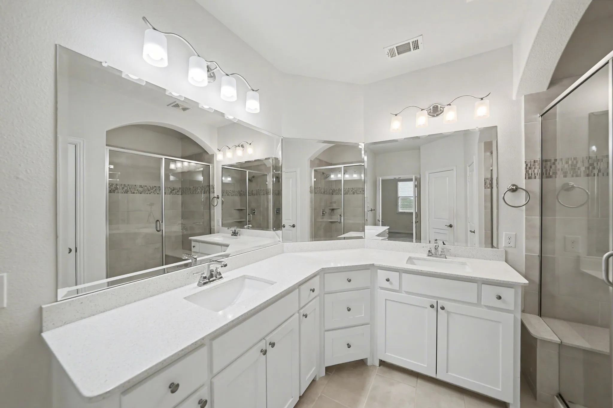 Full bathroom with double vanity, a stall shower, and light tile patterned floors