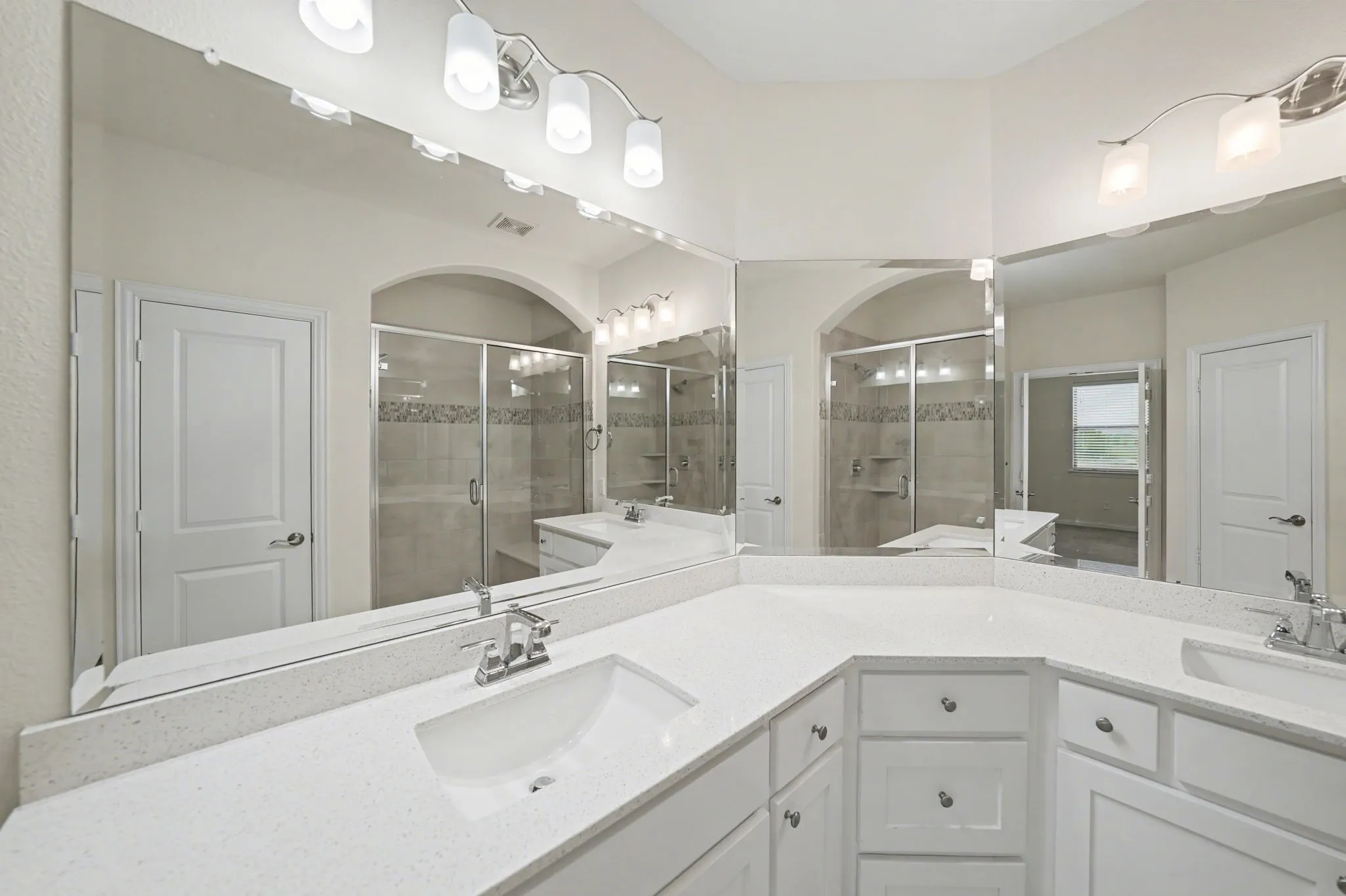 Full bath featuring double vanity and a stall shower