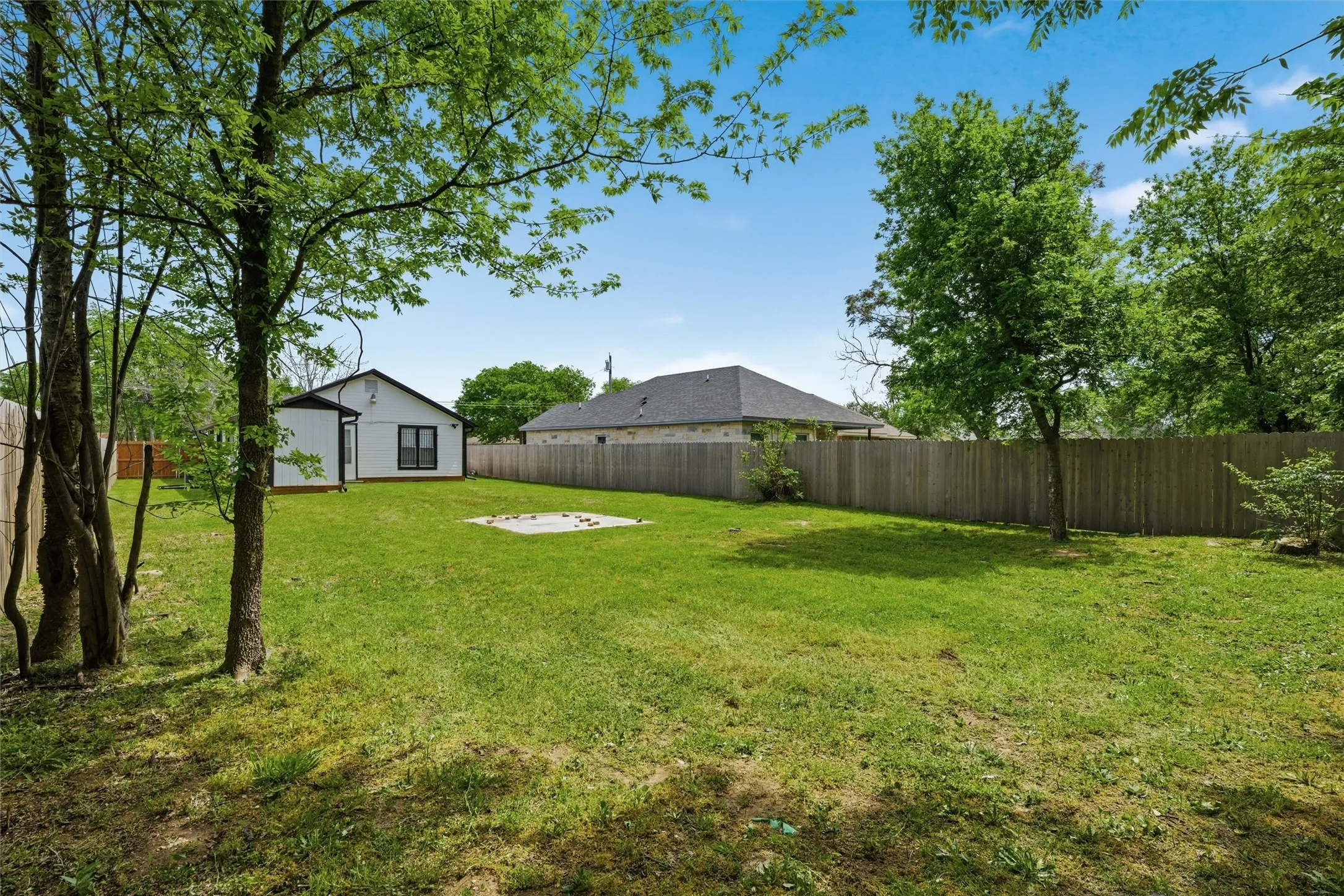 Fenced backyard with an outbuilding