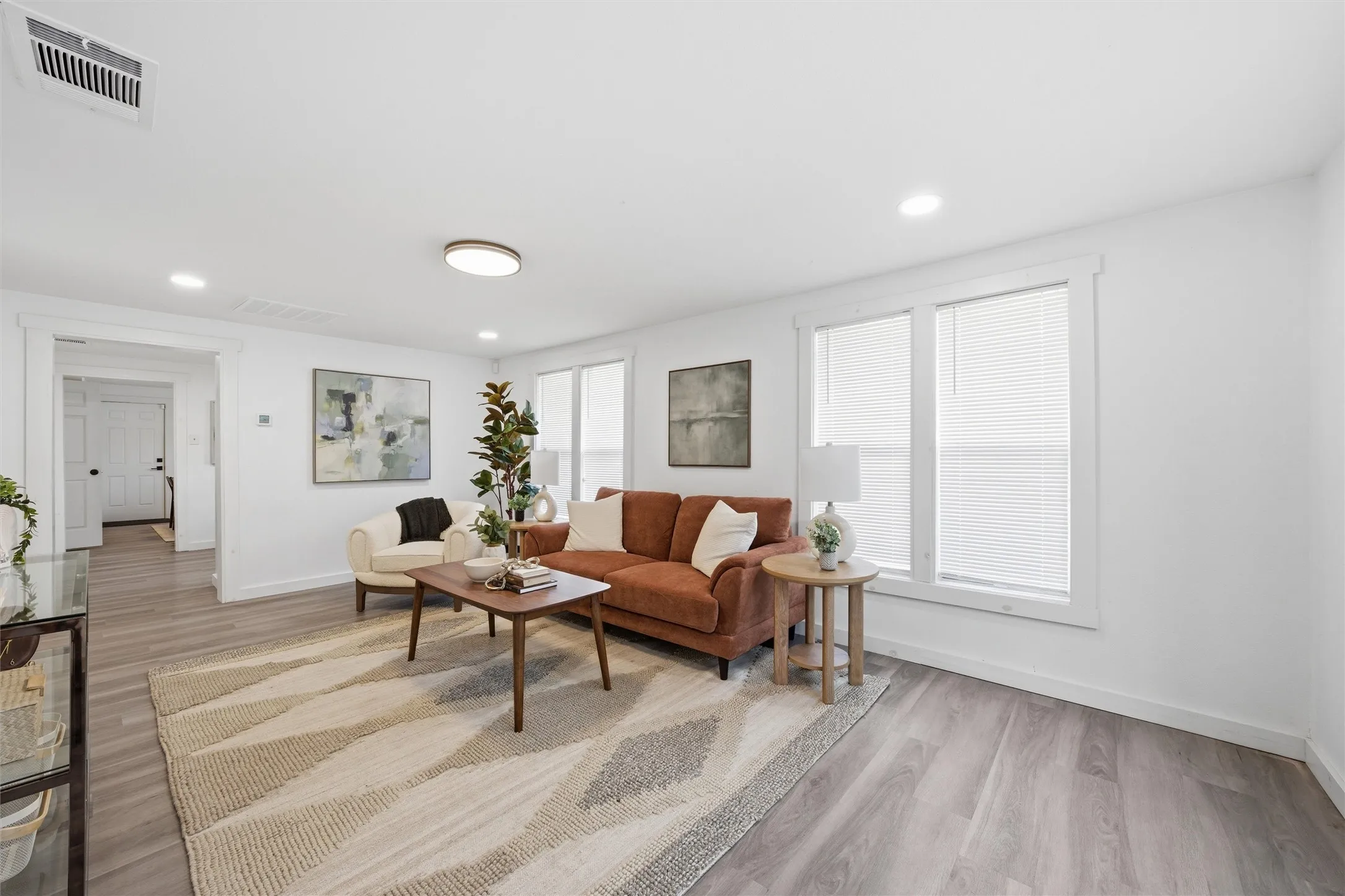 Living room with light wood-style flooring and recessed lighting