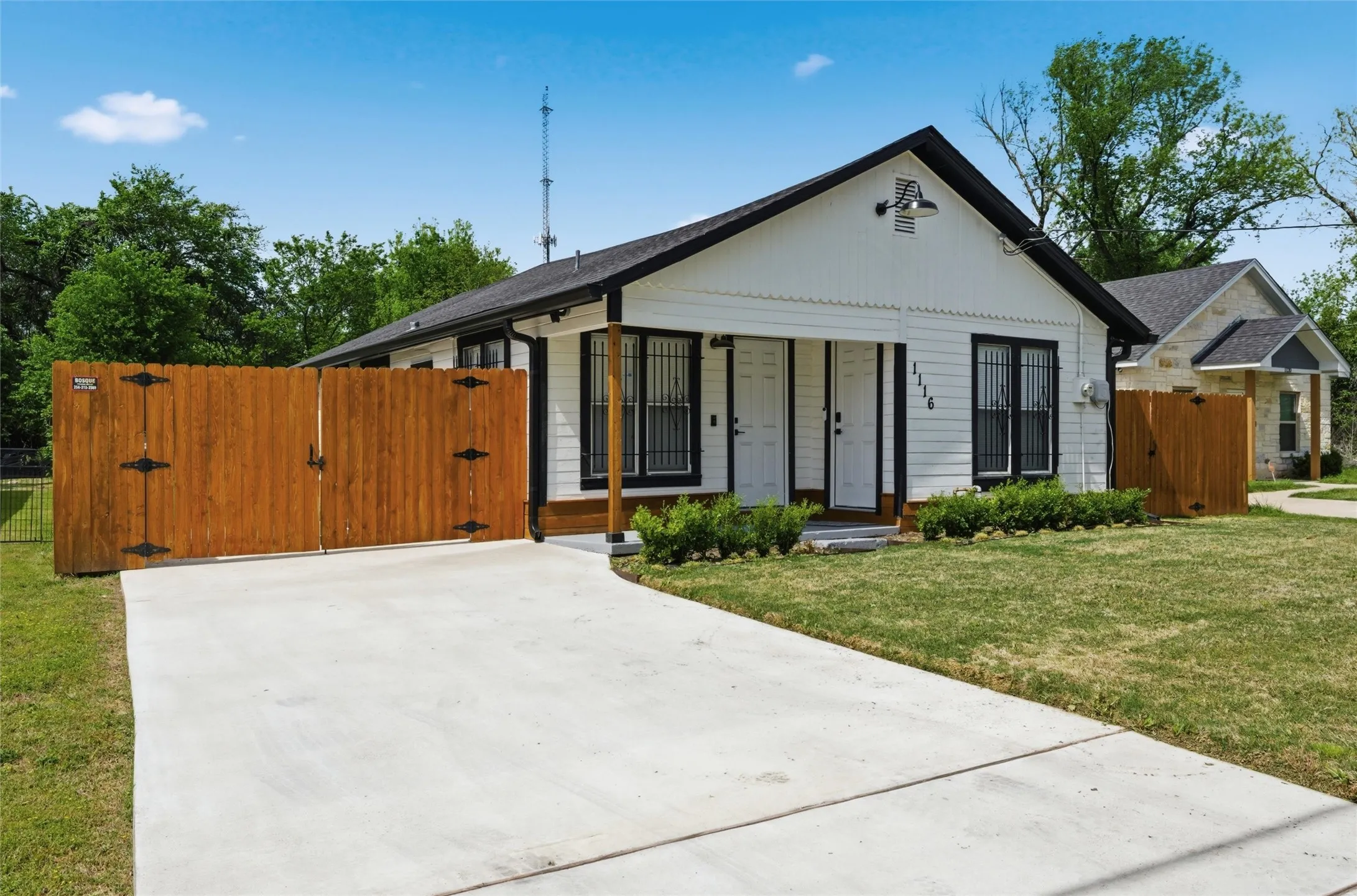 View of front of house with a gate and concrete driveway