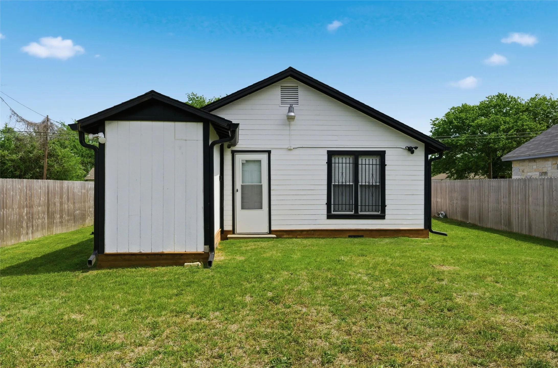 Rear view of house featuring a fenced backyard
