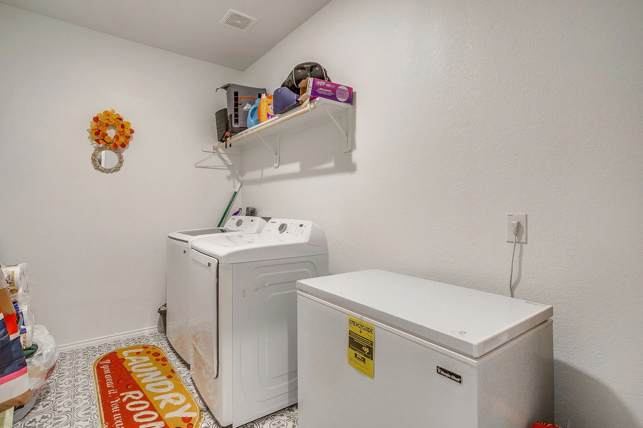 Laundry room with hang up rack and room for a freezer too.