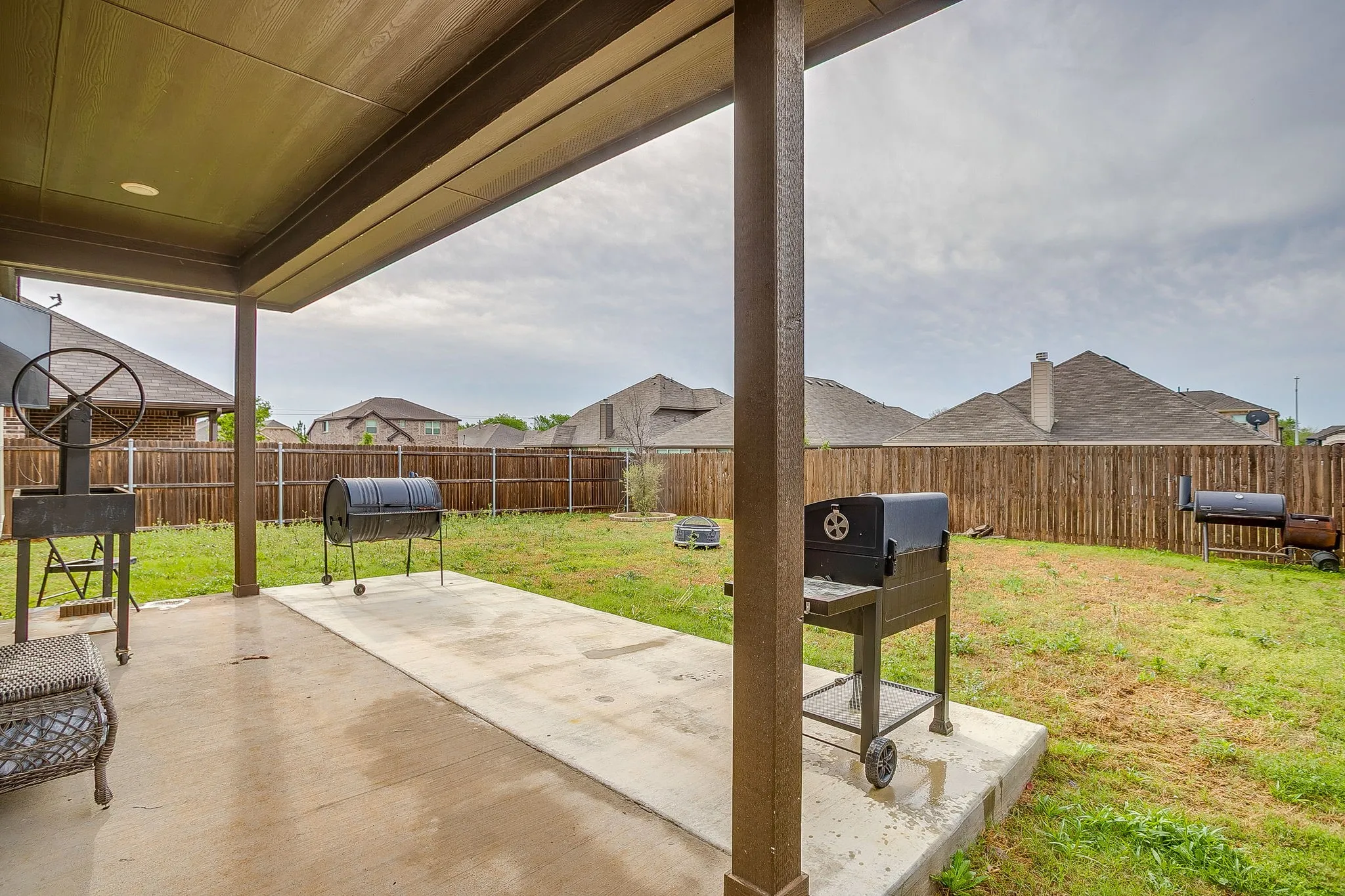 Privacy fenced backyard with covered and open patio space.