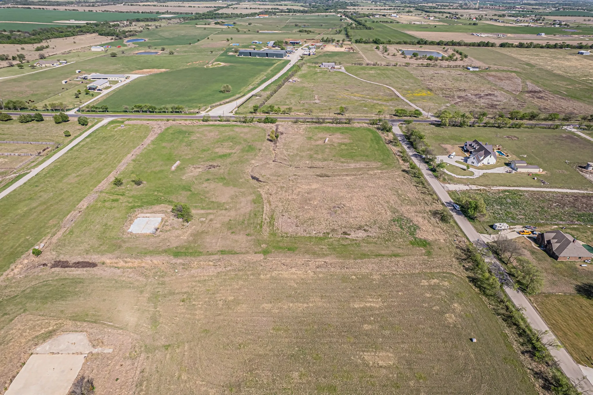 Aerial overview of property's location featuring rural landscape and extensive farmland