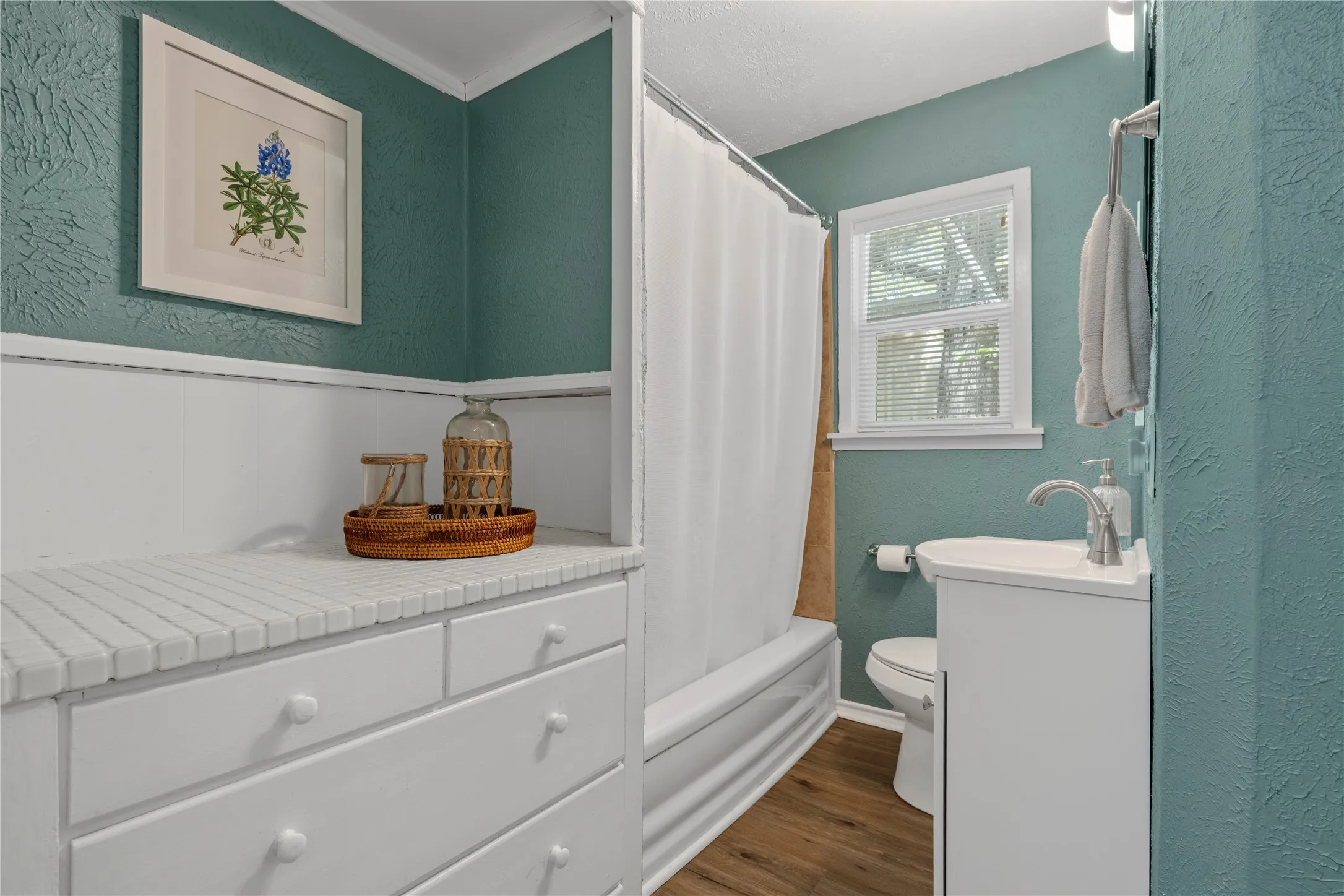 Full bathroom with a textured wall, vanity, dark wood-style floors, shower / bath combo, and a textured ceiling