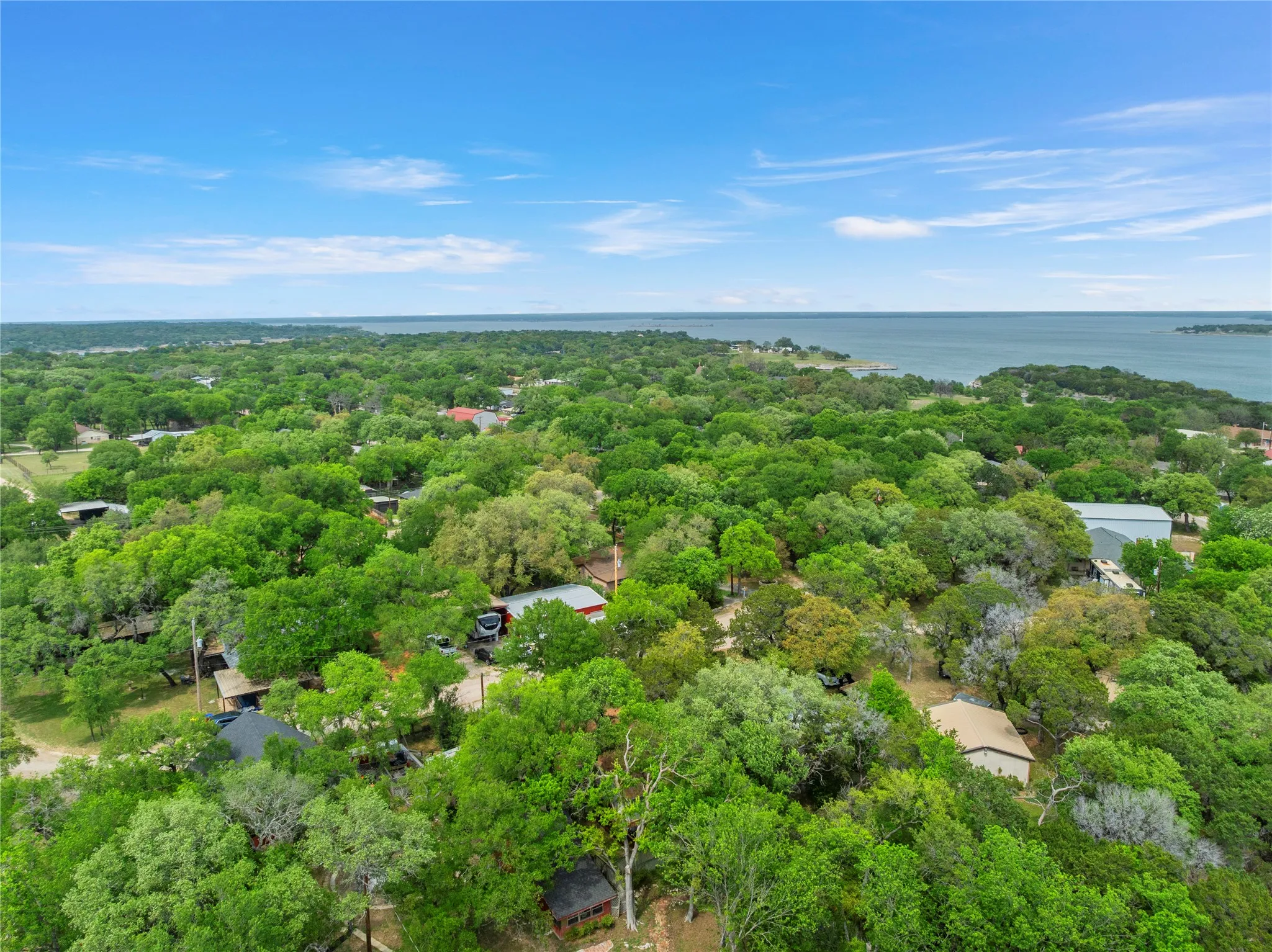Drone / aerial view of a large body of water and a heavily wooded area