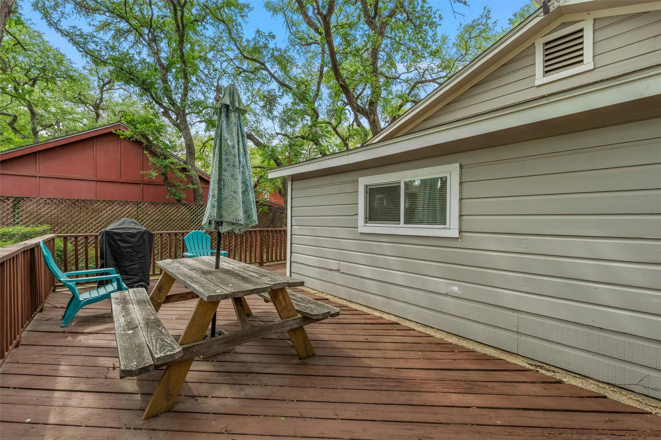 Wooden terrace featuring outdoor dining area and grilling area