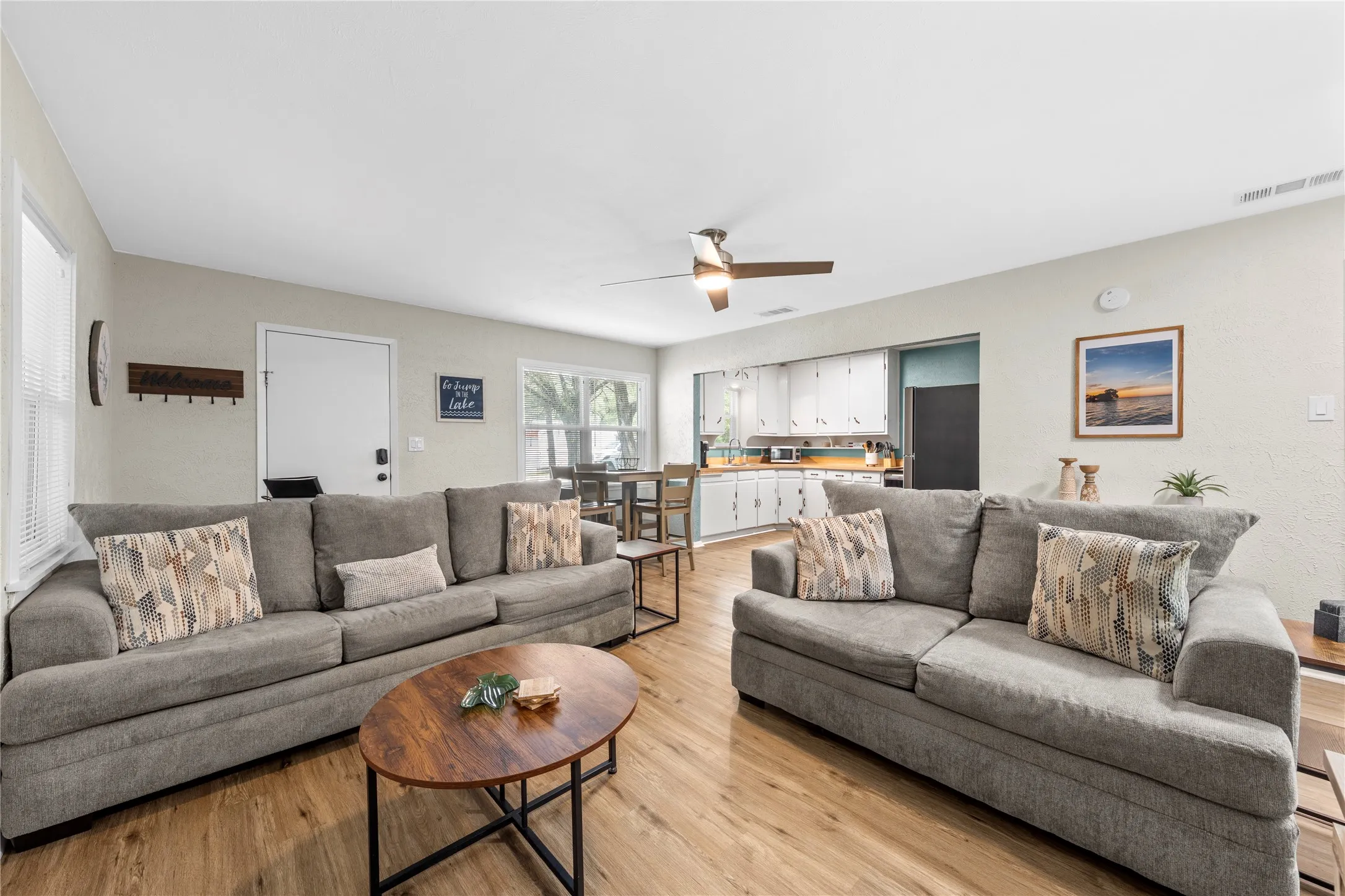 Living area with light wood-style floors and ceiling fan