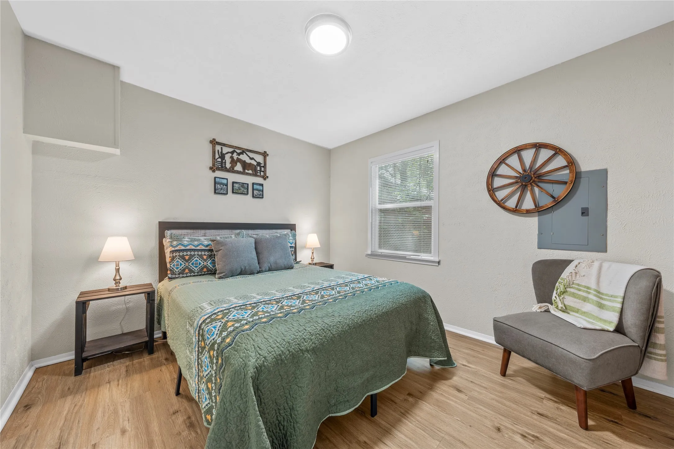 Bedroom with electric panel and light wood finished floors