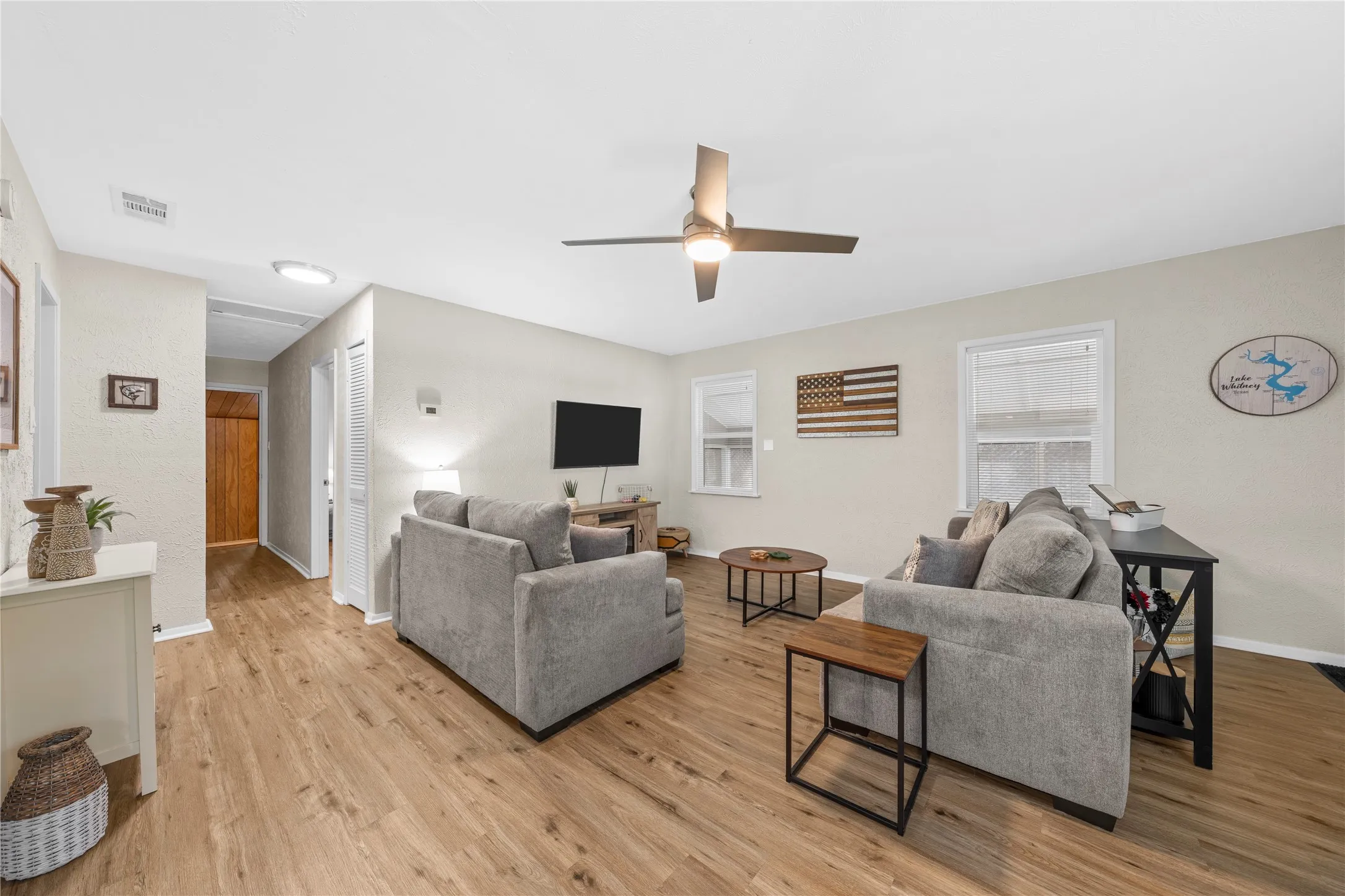 Living room with a ceiling fan and light wood-style floors