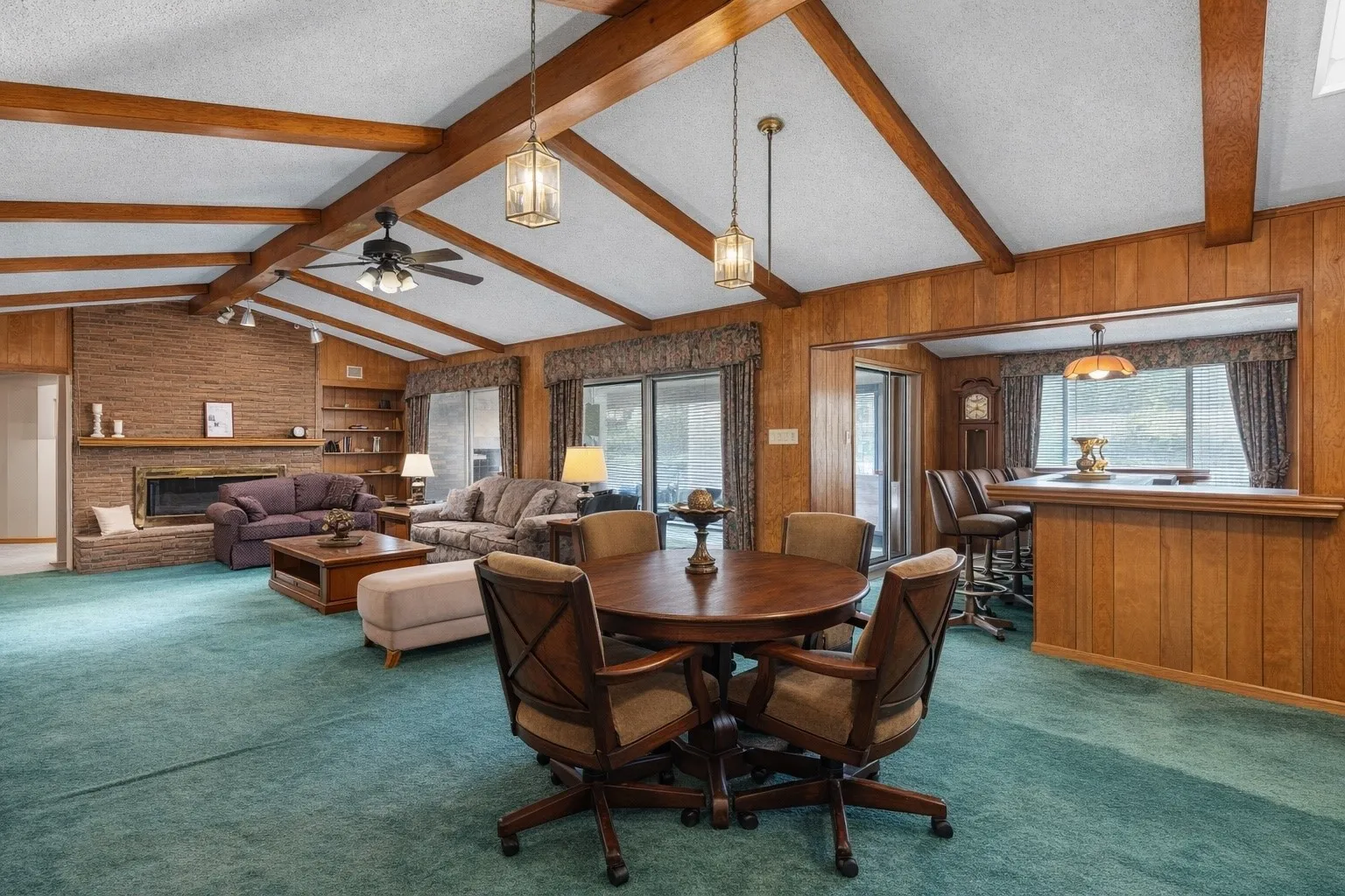 Spacious living room with wood beam ceiling, fireplace and wet bar.
