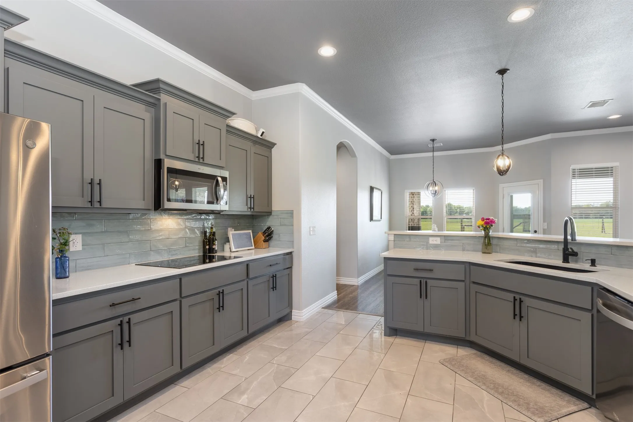 Enjoy the backyard view from the kitchen.  Large windows across the back of the home provide views for all.