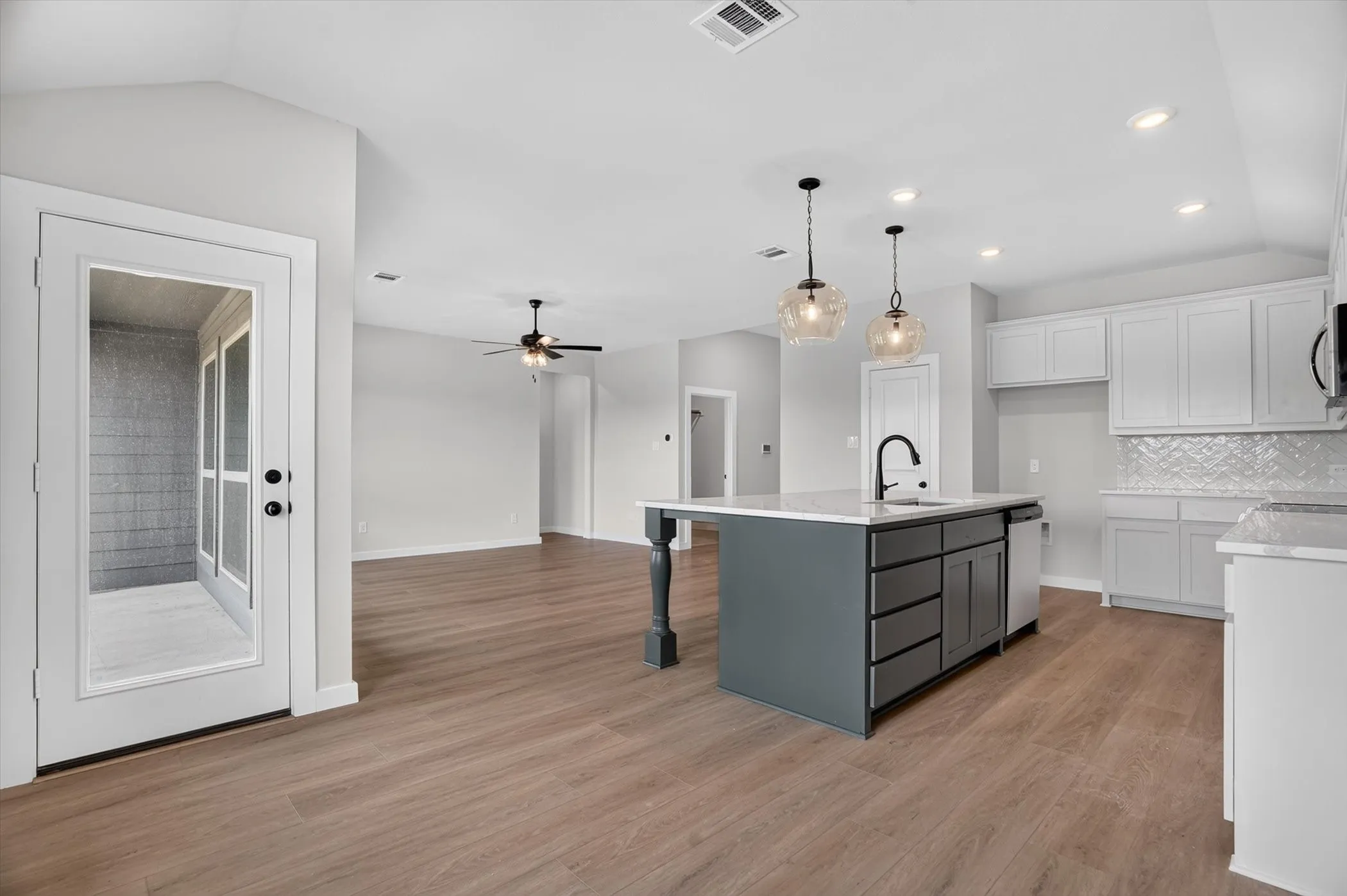 Open-concept living area featuring wood-finish flooring, recessed lighting, and a ceiling fan