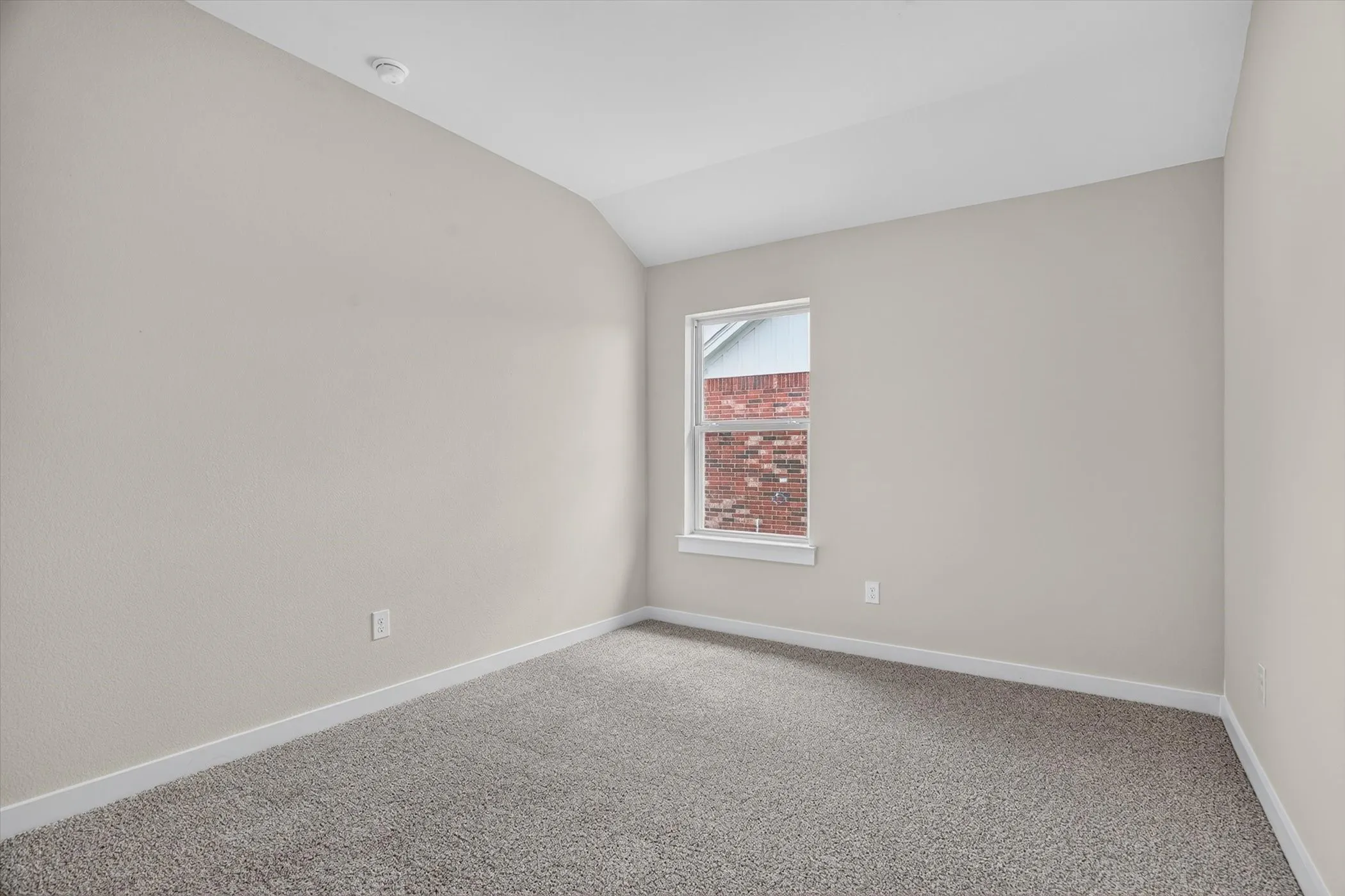 Neutral wall tones, gray carpeting, and a white window frame