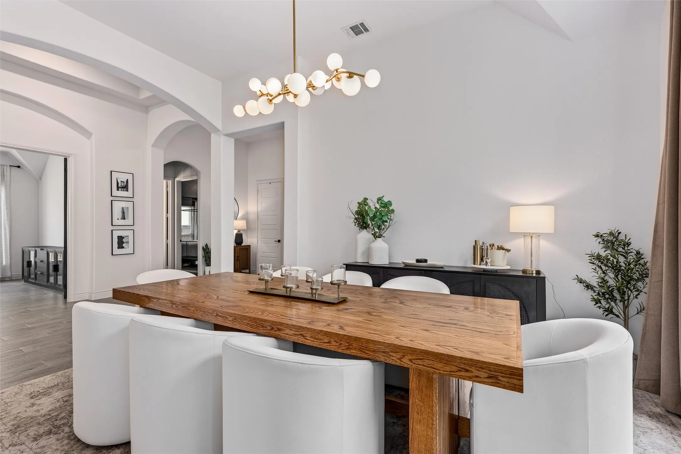 Large kitchen with open concept living, quartz countertops, and stylish pendants