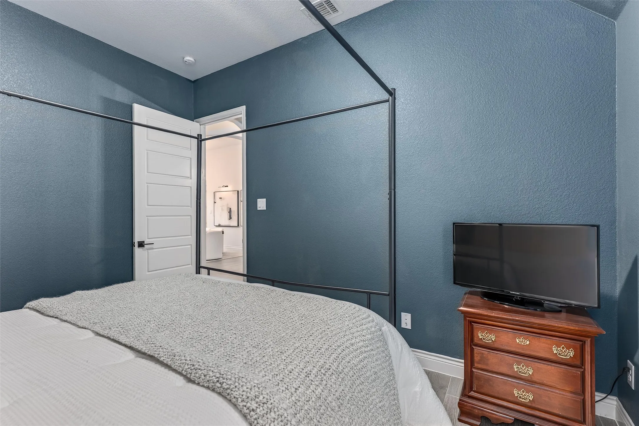 Secondary bedroom in the middle of the home with decorative lighting.