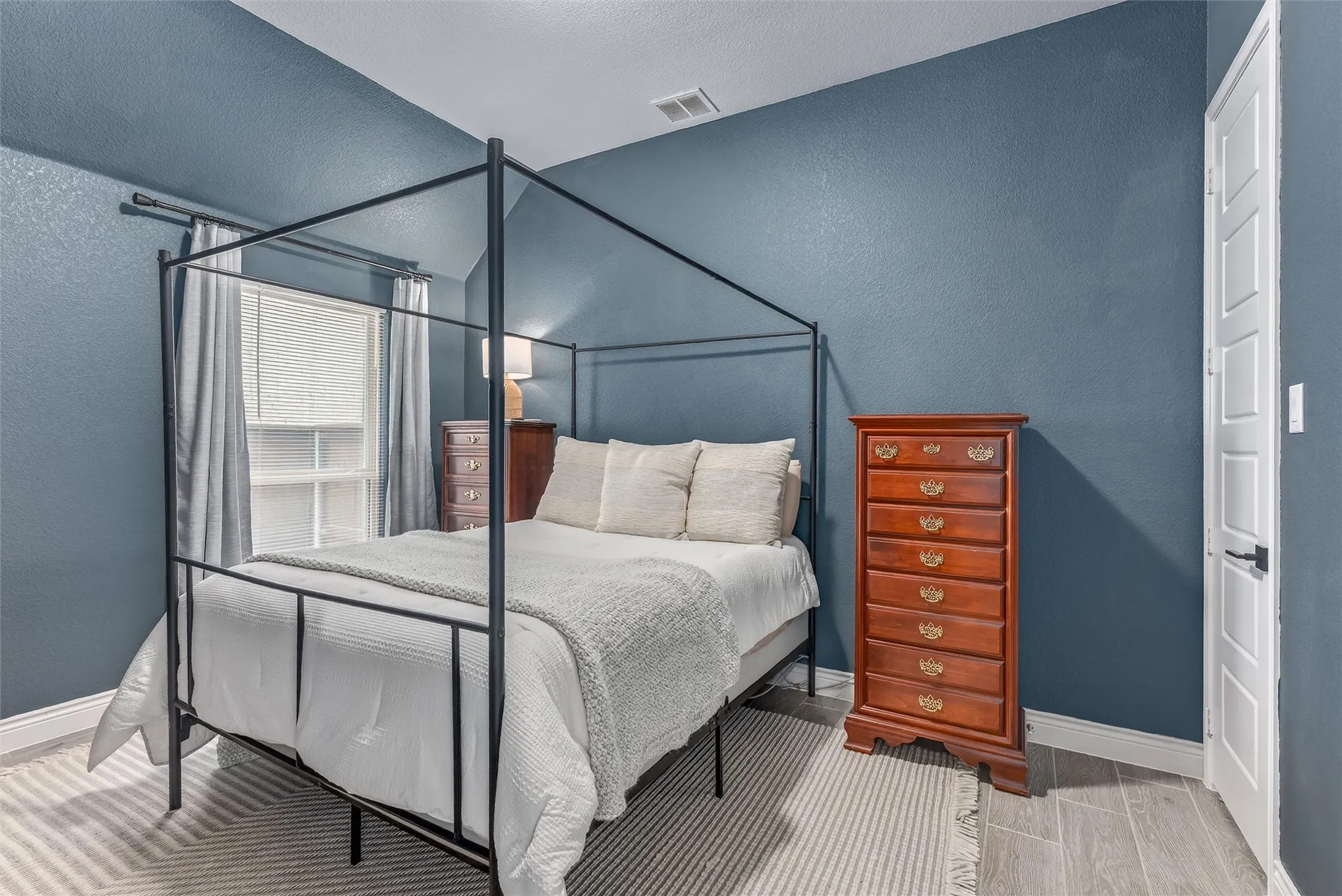 Secondary bedroom with a walk in closet and decorative lighting.