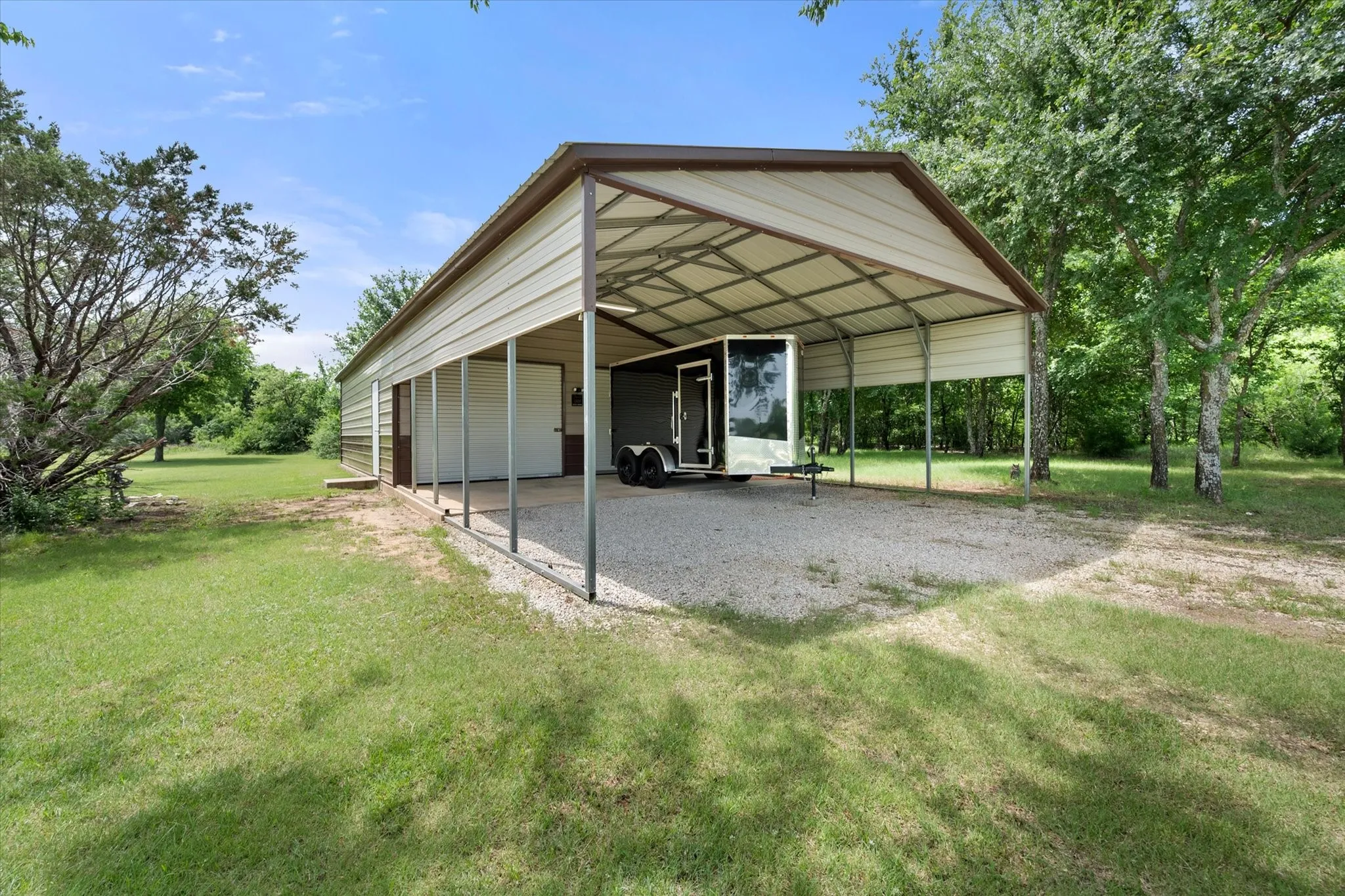 Metal carport structure with a gravel base, providing covered parking