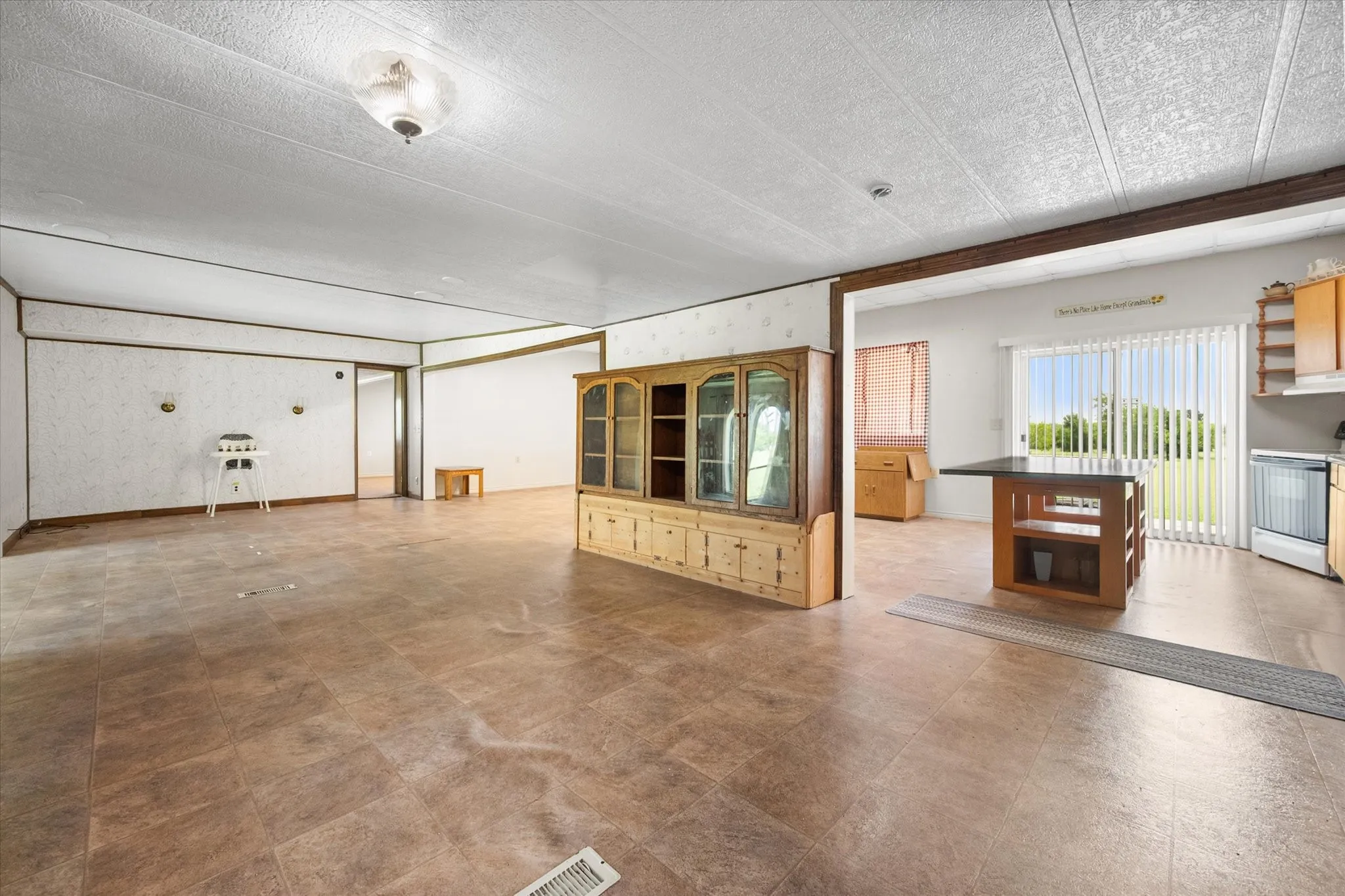 Open-concept living area with tile-look flooring and a textured ceiling