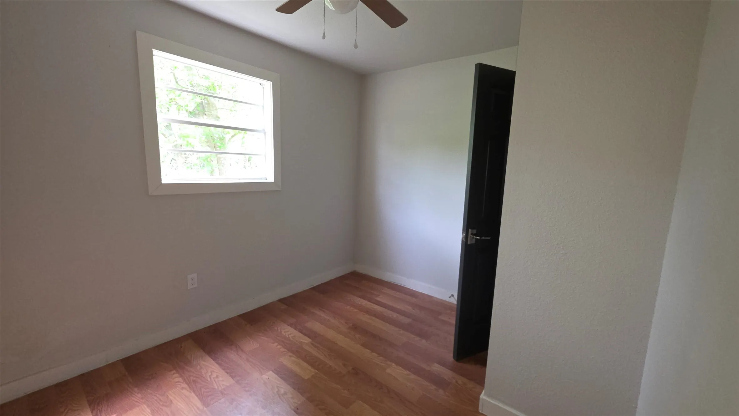 Unfurnished room with wood finished floors and a ceiling fan