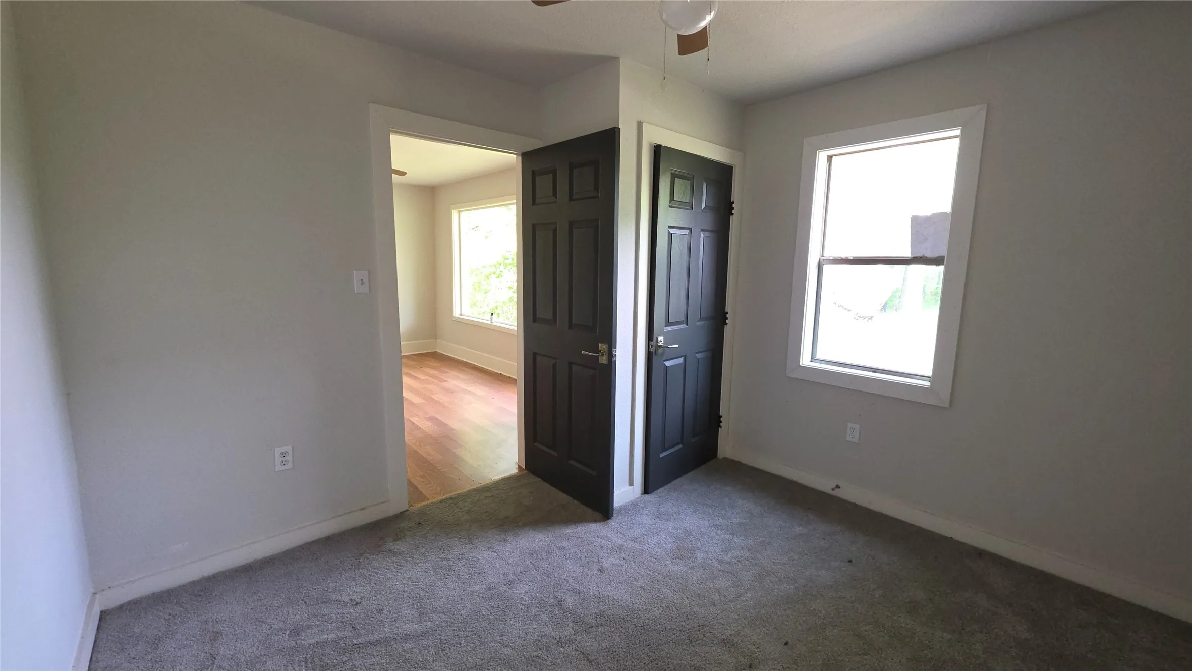 Unfurnished bedroom with carpet, multiple windows, and ceiling fan