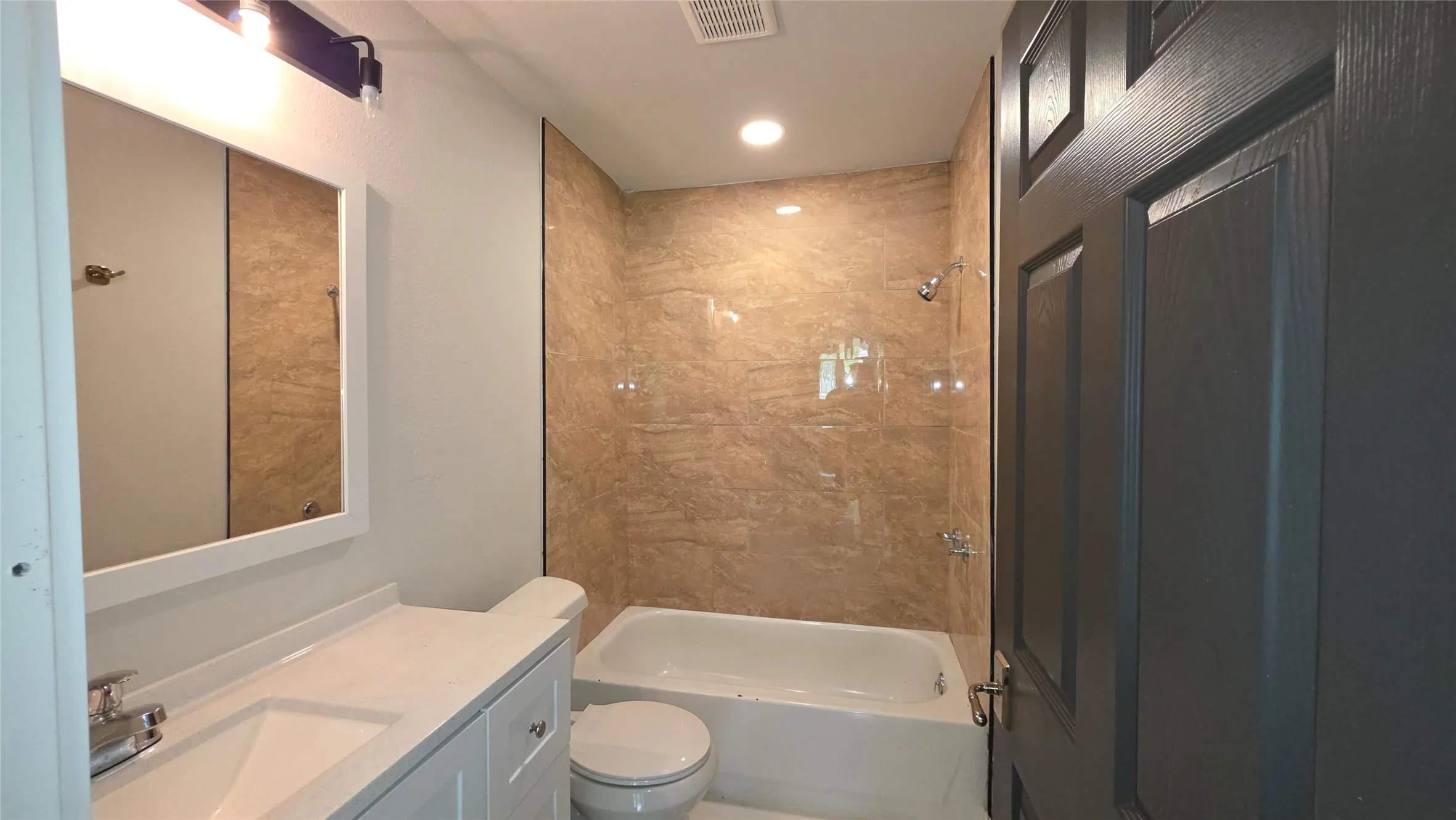 Bathroom with vanity, washtub / shower combination, and recessed lighting