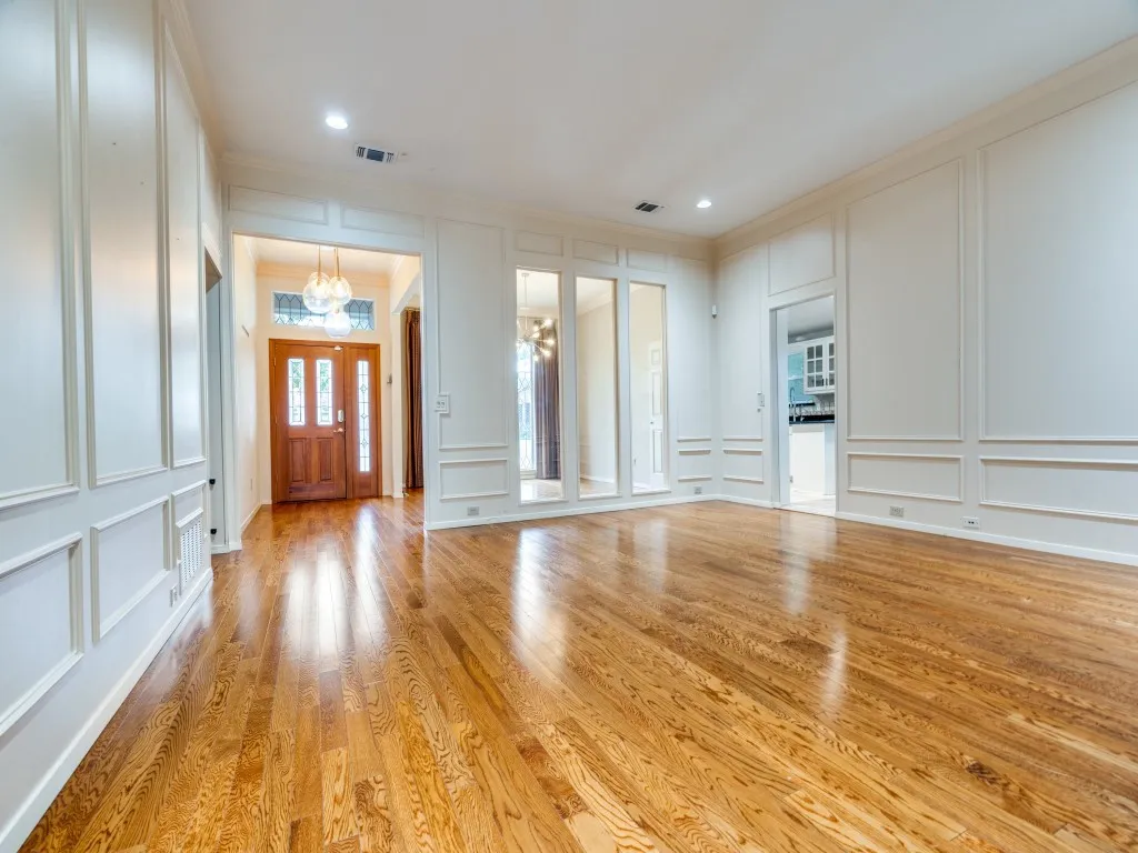 Entrance foyer with ornamental molding, light wood-type flooring, and an inviting chandelier